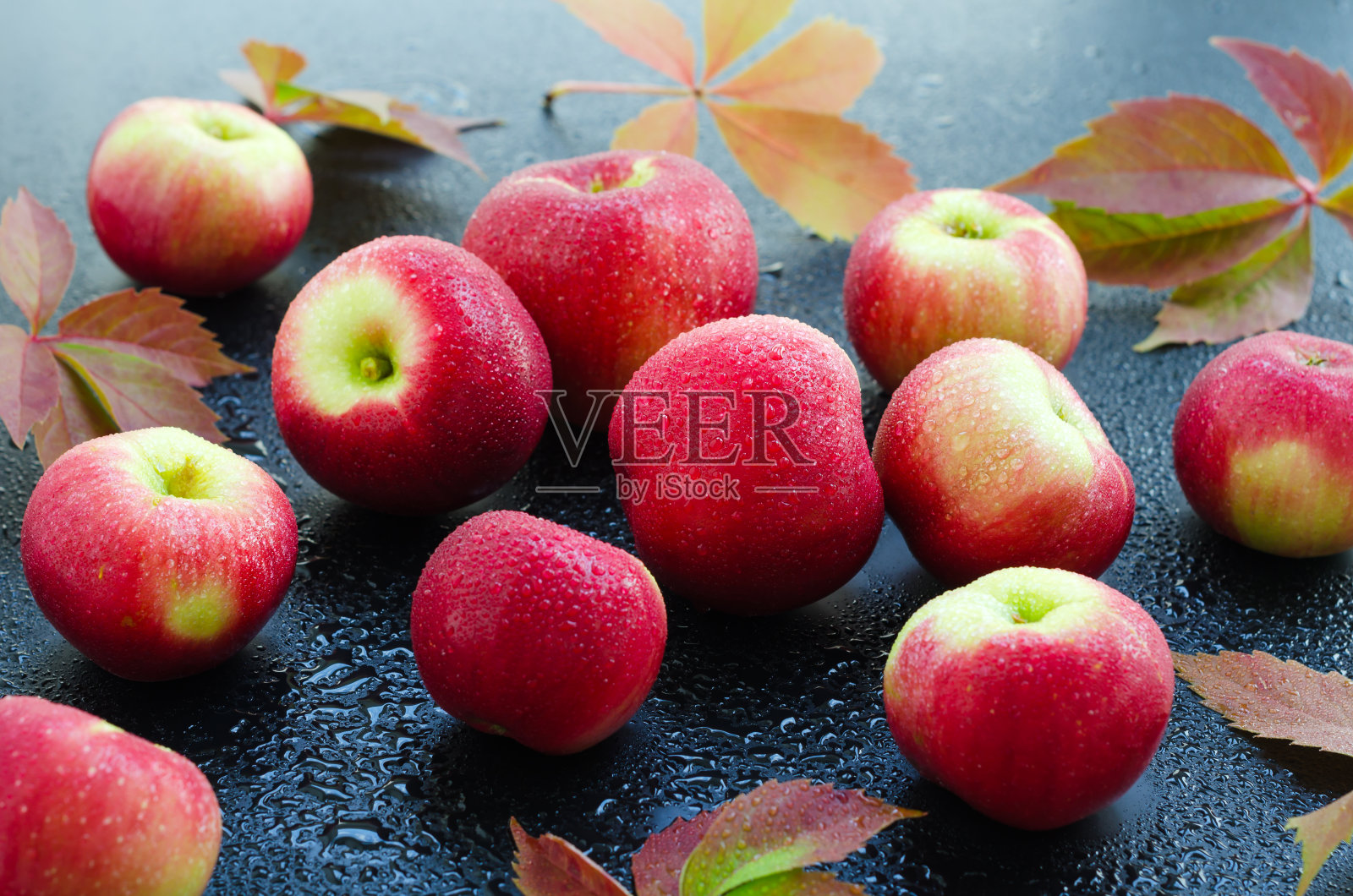 红色的苹果与水滴在暗潮湿的背景照片摄影图片