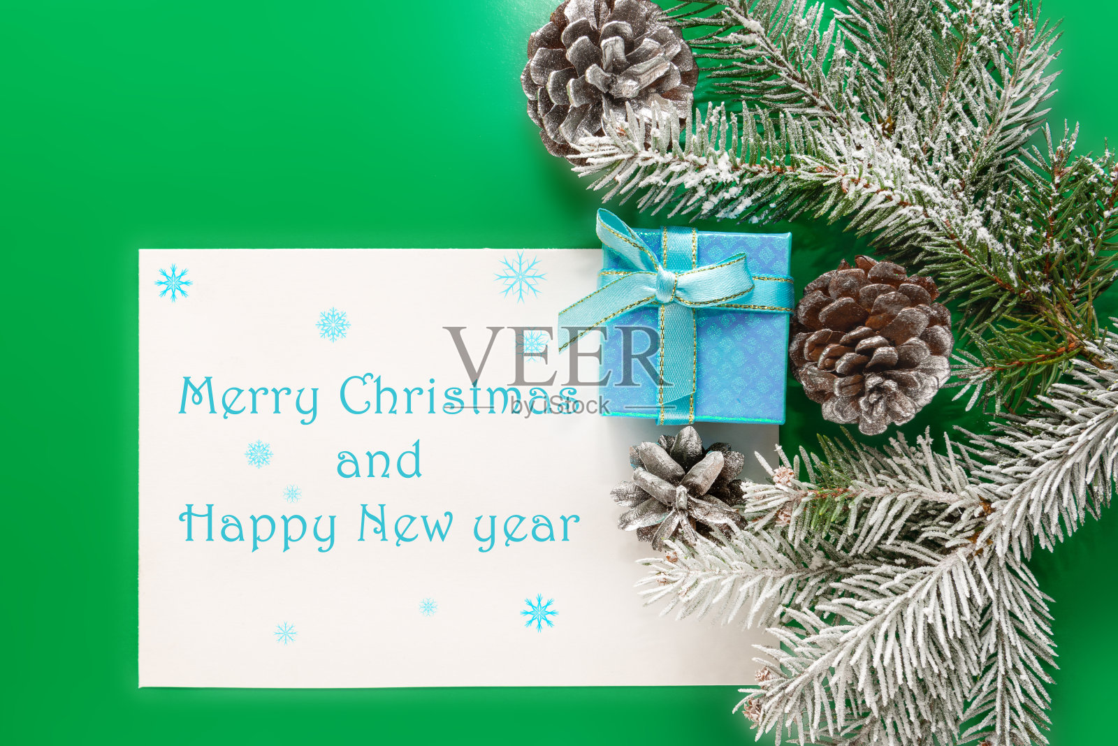 假日装饰,锥形和礼盒的边界上的绿色背景。写着祝福的明信片和圣诞祝福的短信。圣诞组成。照片摄影图片