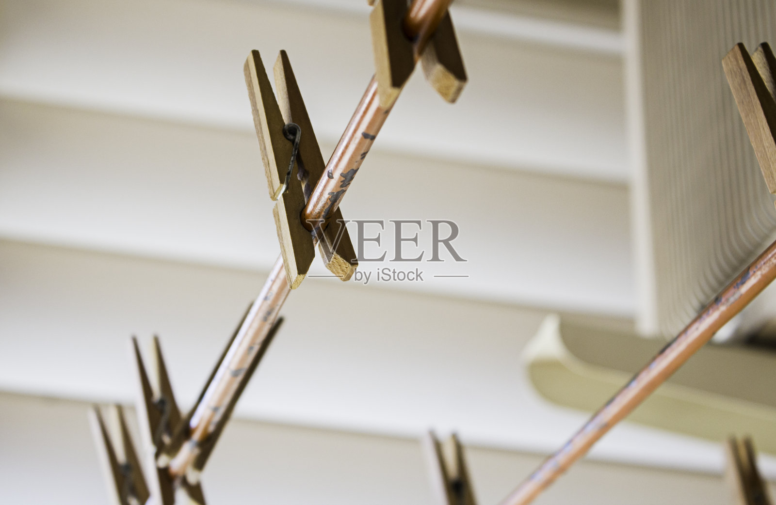 在室内晾衣绳上用镊子夹衣服照片摄影图片