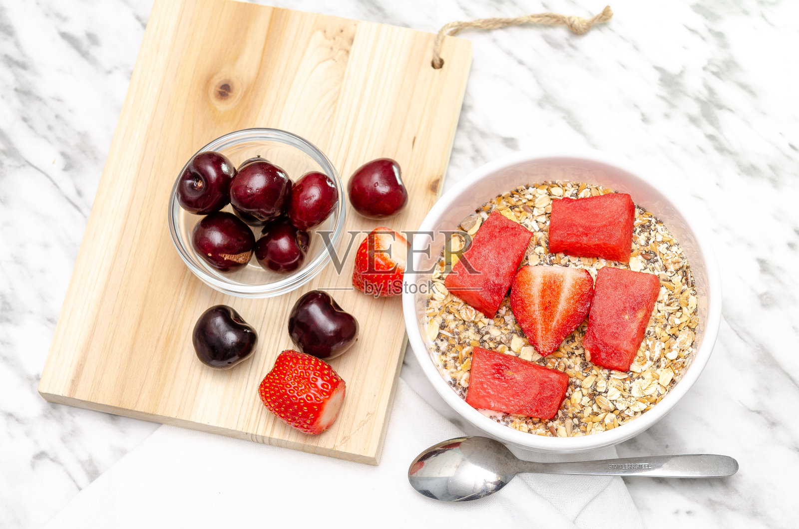 一碗香蕉冰沙和草莓放在木板上照片摄影图片