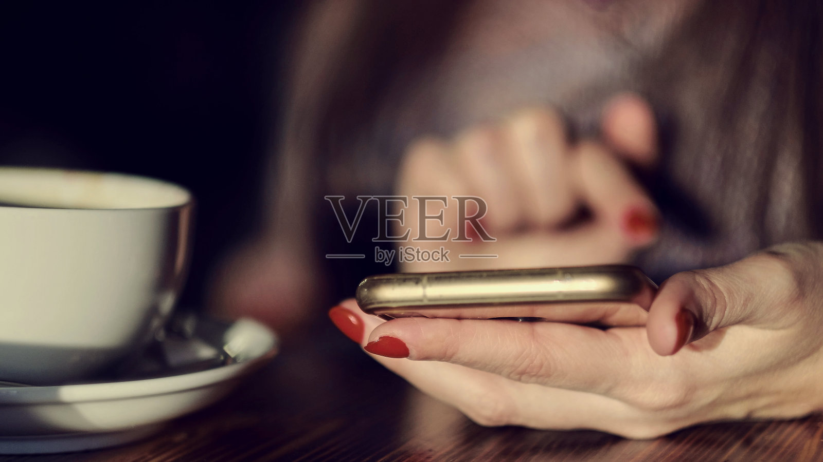 拿着咖啡杯用智能手机的年轻女子。健美的图片照片摄影图片