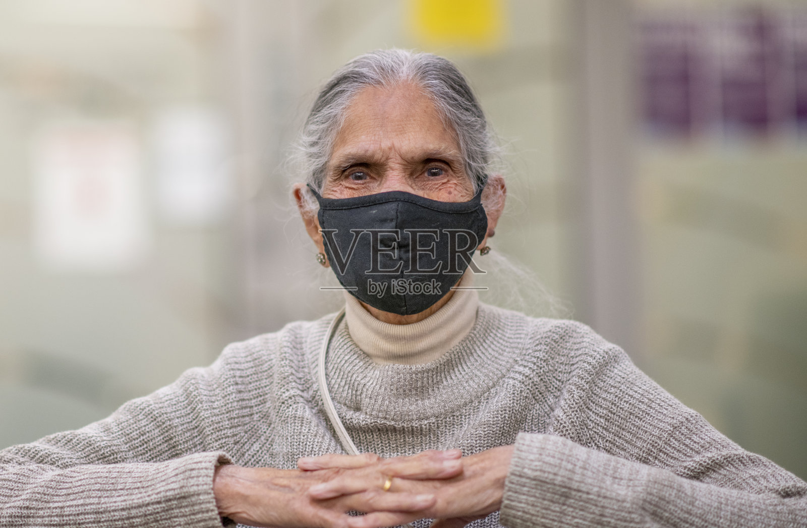 坐在轮椅上戴面具的老妇人照片摄影图片