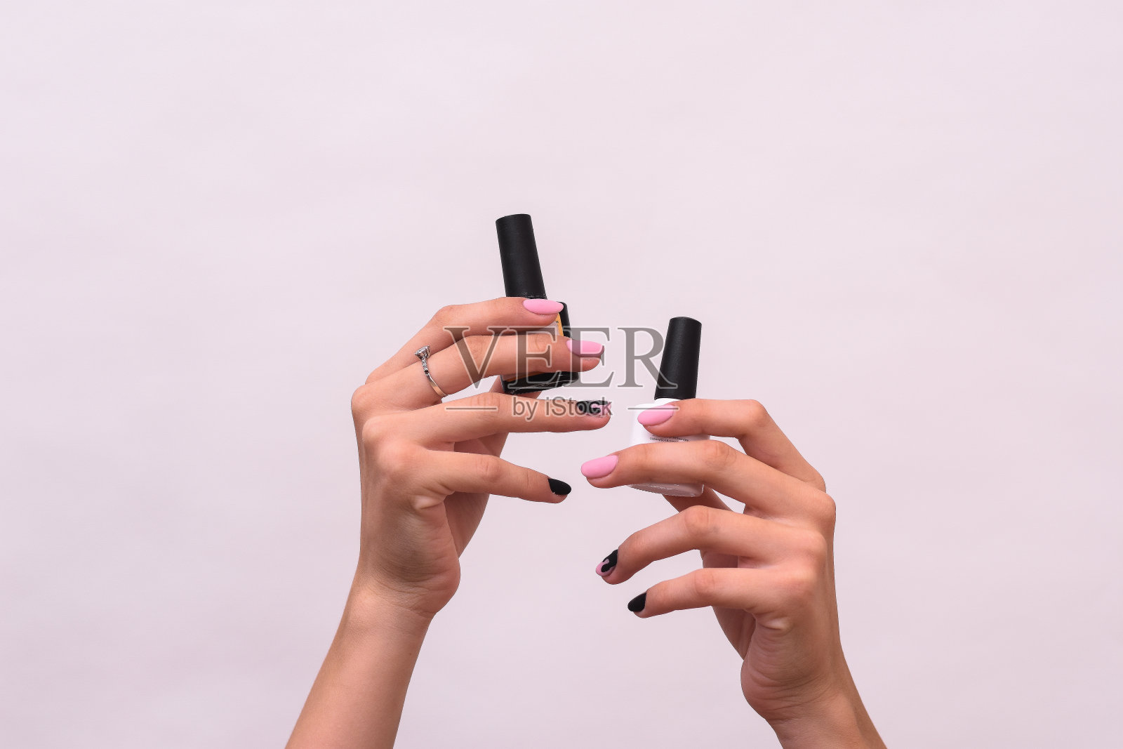 白色背景上一个白人女孩手中的指甲油照片摄影图片