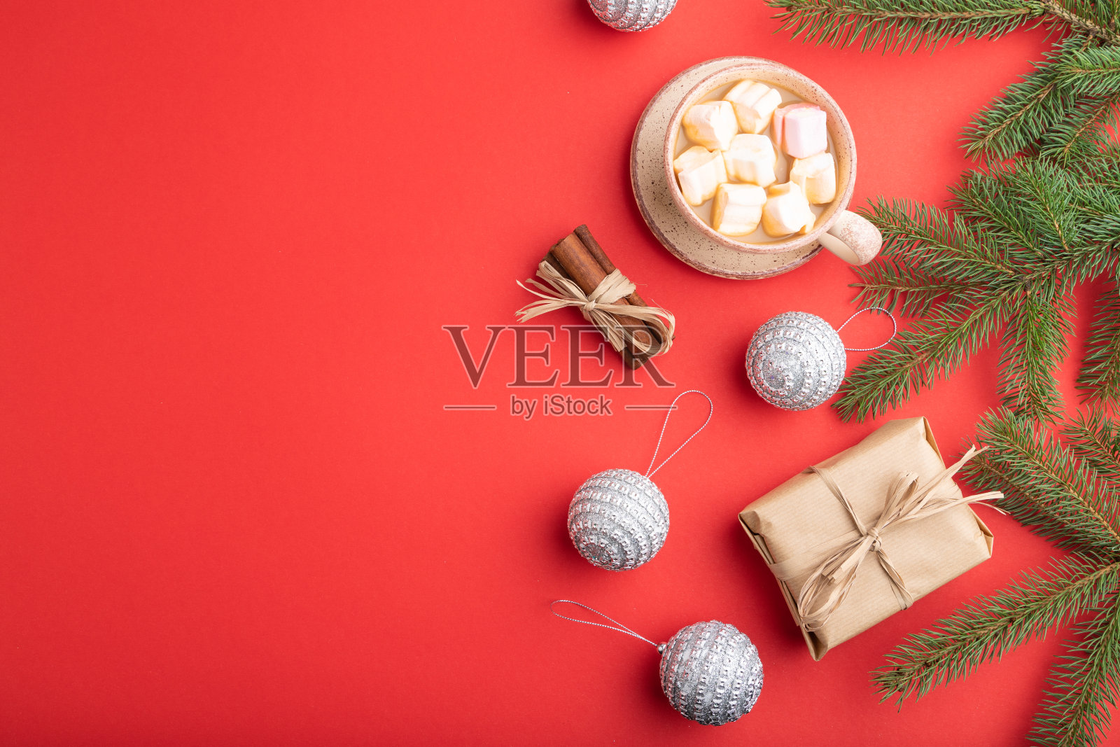 圣诞或新年作文。装饰,盒子,肉桂,银球,杉木和云杉树枝,咖啡杯,在红色的纸背景。侧视图,拷贝空间。照片摄影图片