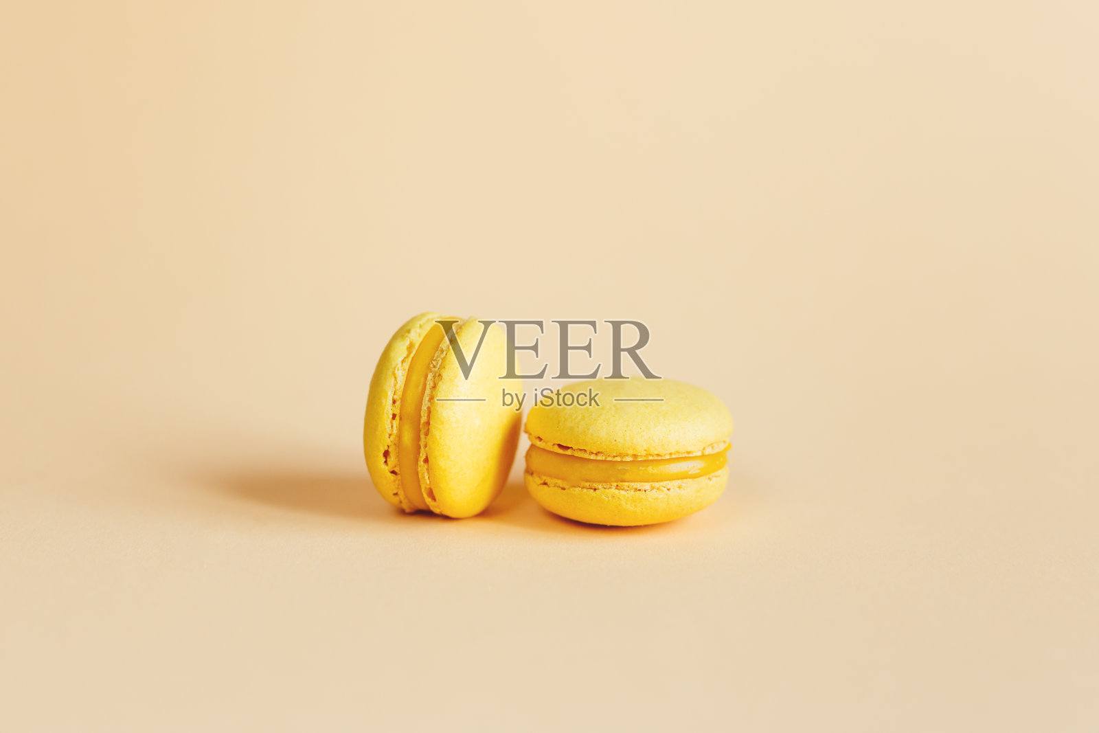 美味的法式马卡龙在柔和的黄色背景上。照片摄影图片