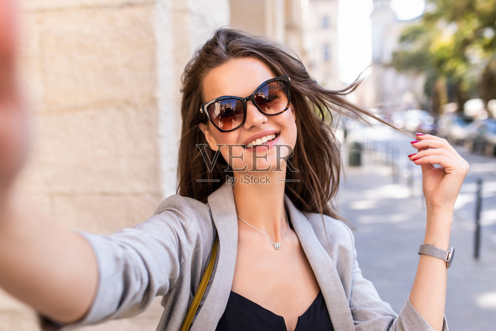 微笑的年轻女子在城市街道上自拍照片摄影图片