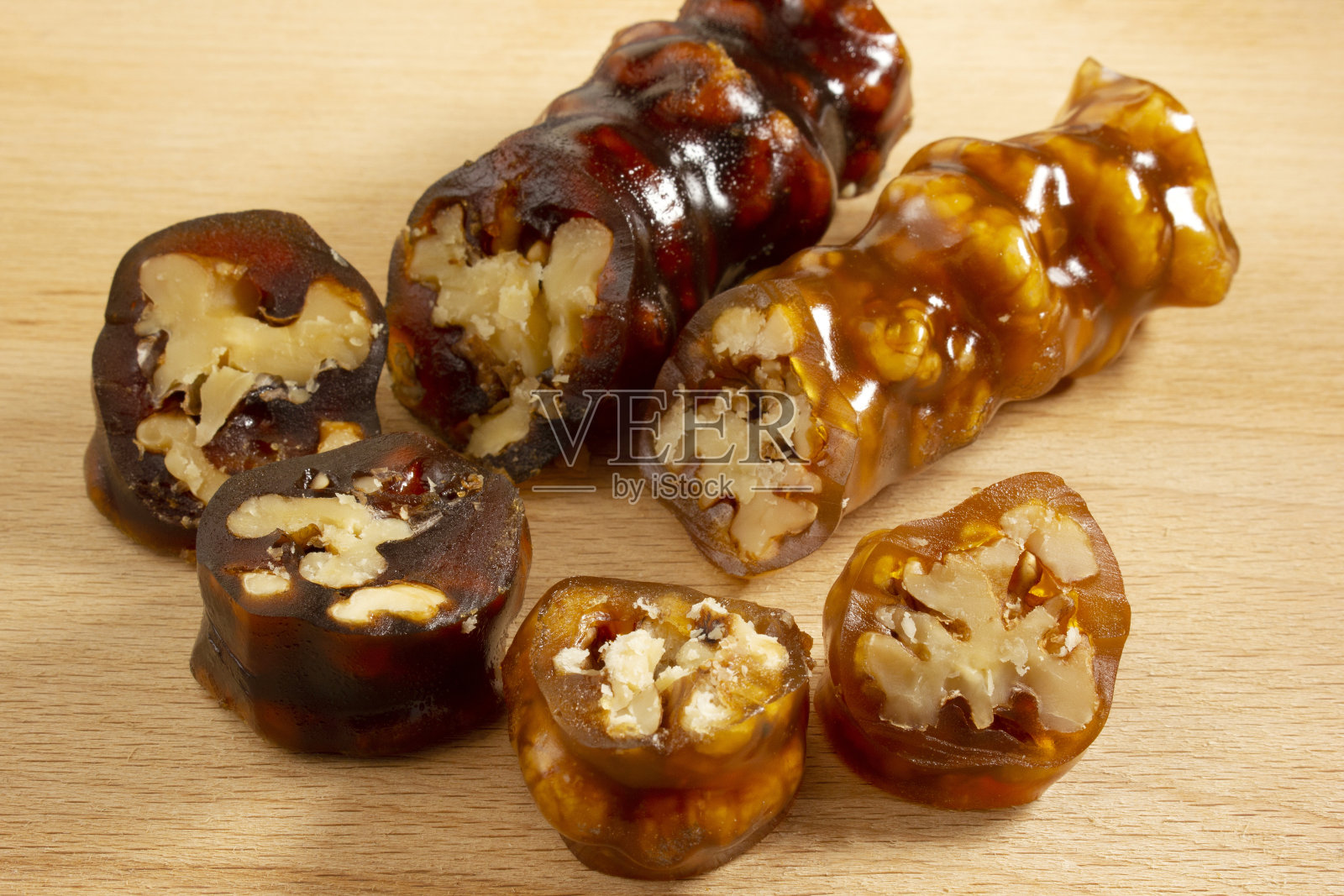 把核桃串在绳子上,蘸上糖蜜淀粉。Churchkhela。核桃sujuk。照片摄影图片