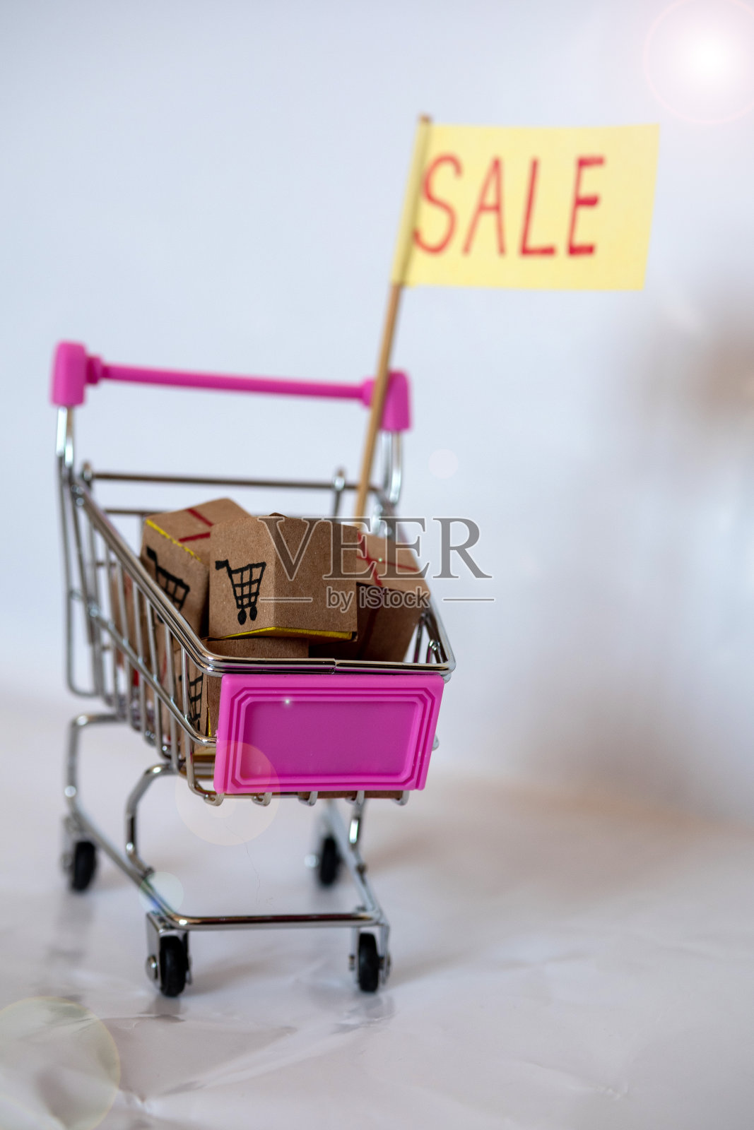 购物大减价!白色背景的手推车里的盒子。照片摄影图片