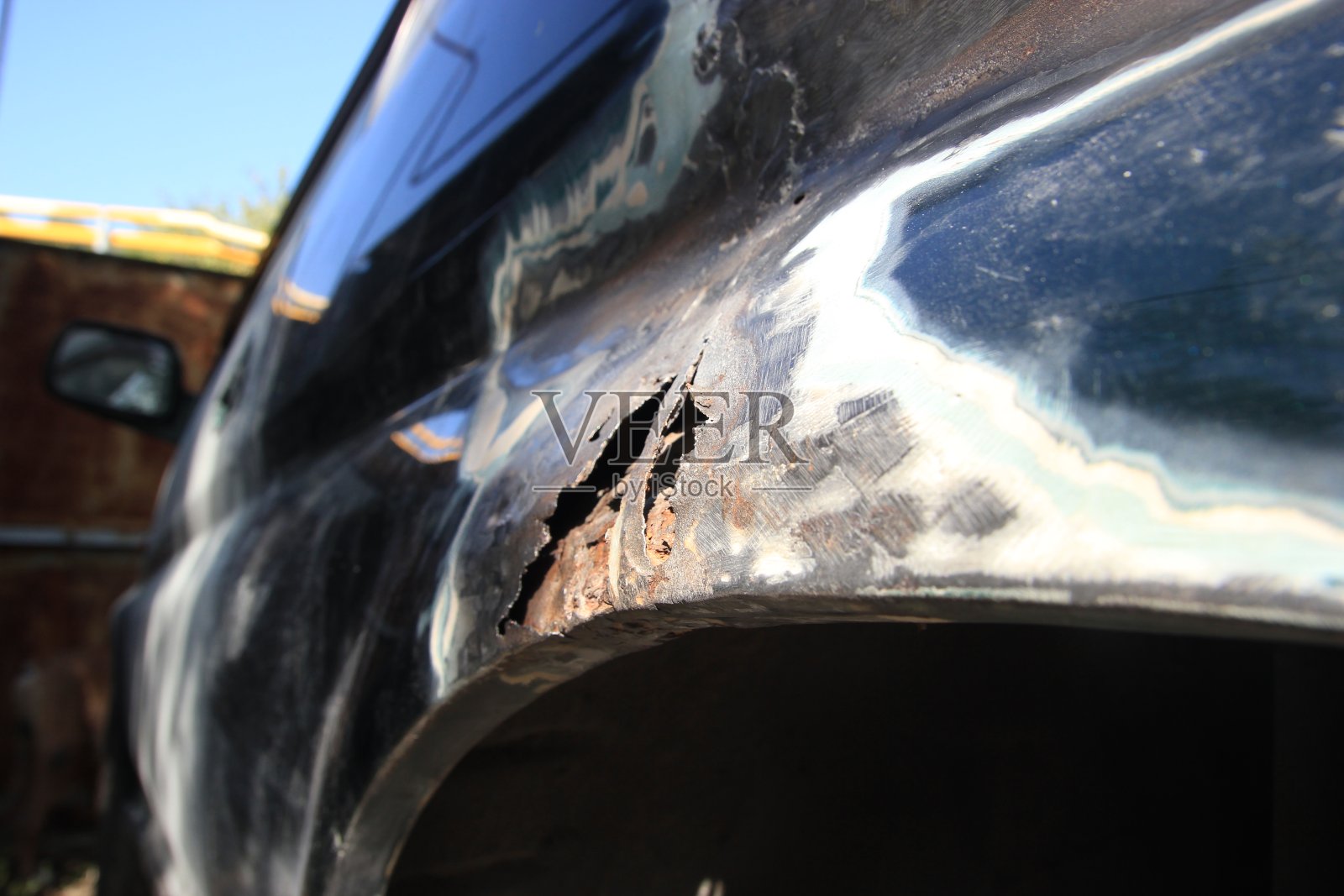 汽车挡泥板上的金属锈蚀,锈孔。汽车车身修复。侧视图照片摄影图片