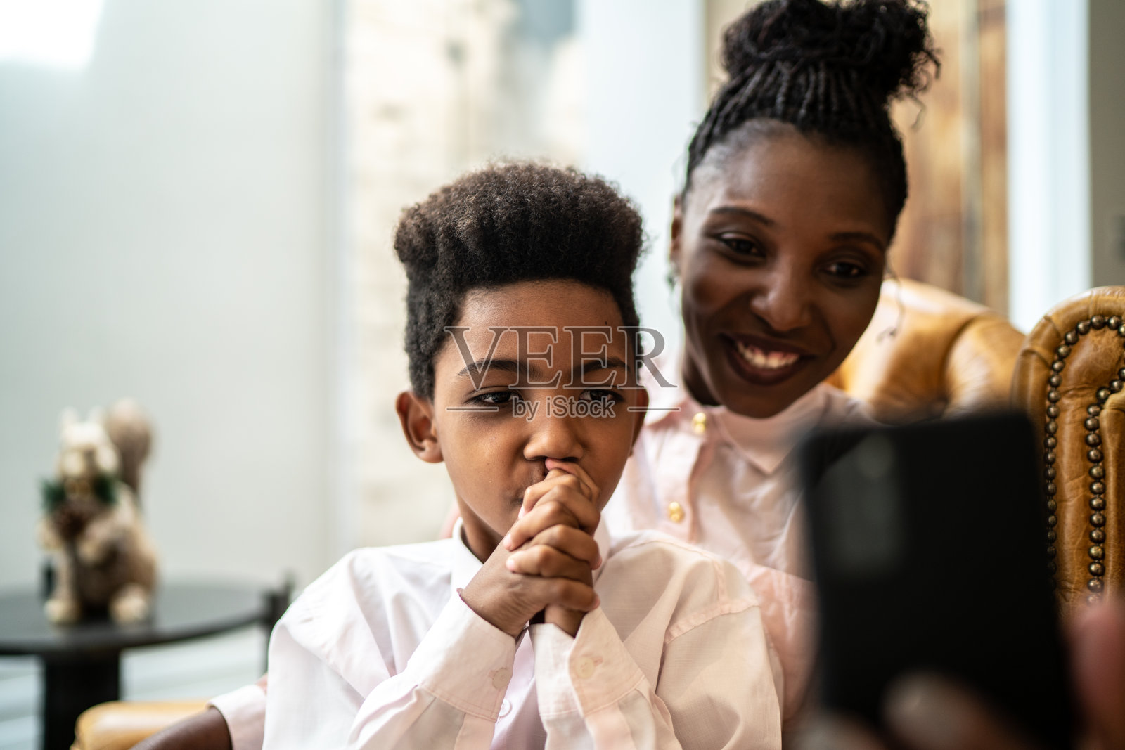 母亲和儿子在家里用智能手机进行视频通话照片摄影图片