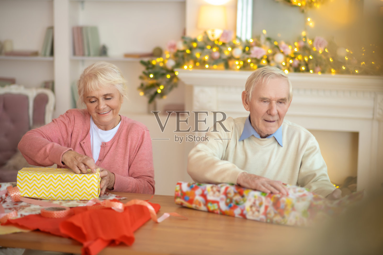 一对老夫妇正在包装圣诞礼物,看上去很有感情照片摄影图片