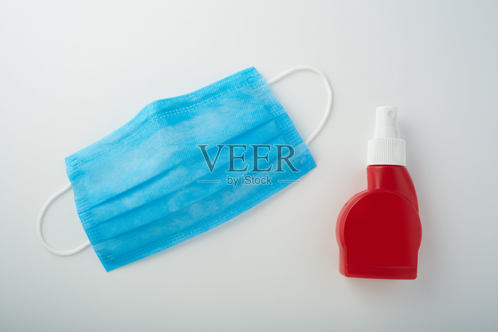 预防感染。外科防护口罩和消毒剂喷雾瓶白色背景照片摄影图片