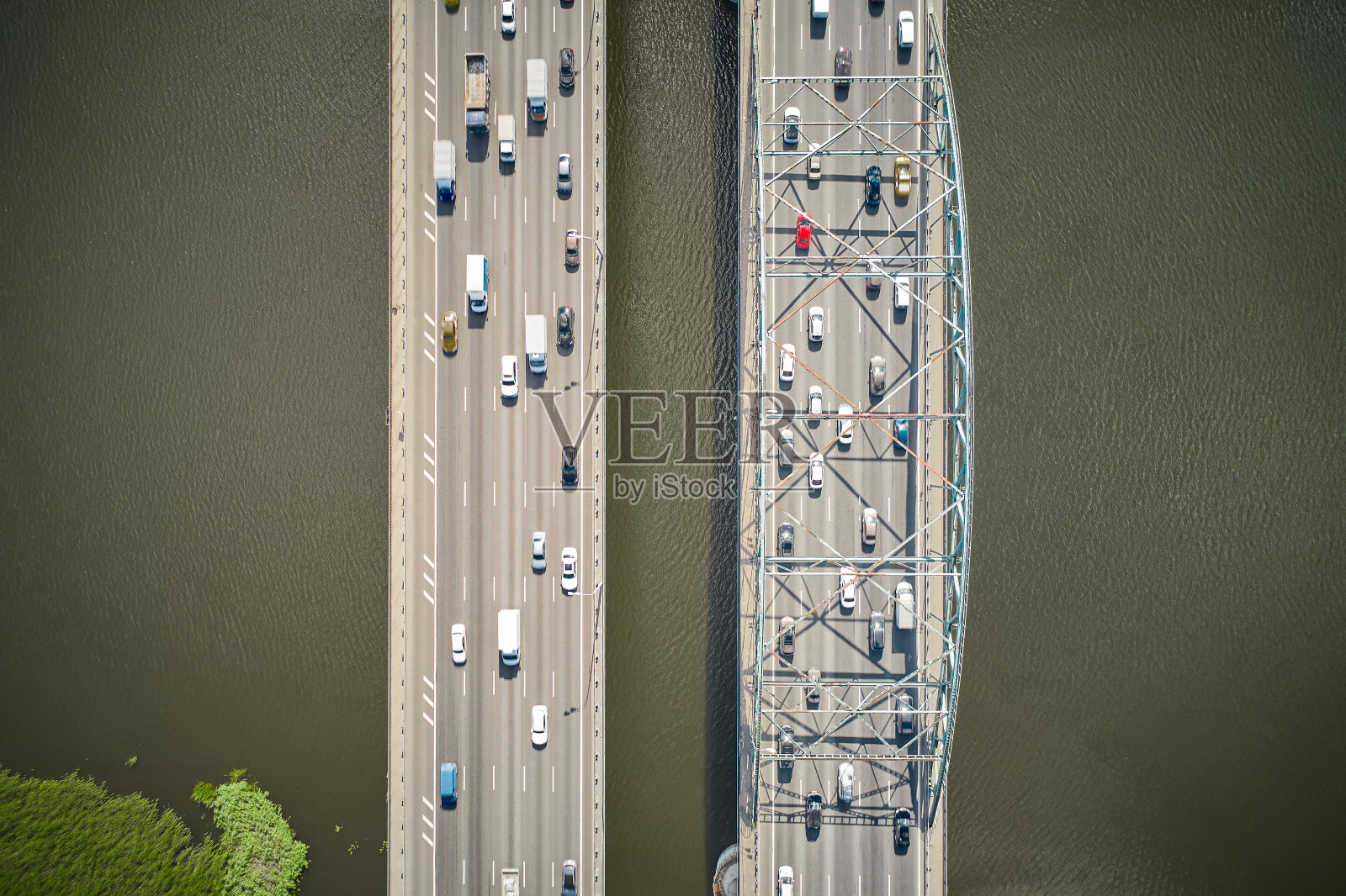 河上有两座桥,交通堵塞。汽车正在穿越这座双桥。两个垂直的道路。直接看下来。从无人机上鸟瞰。在阳光之下。照片摄影图片