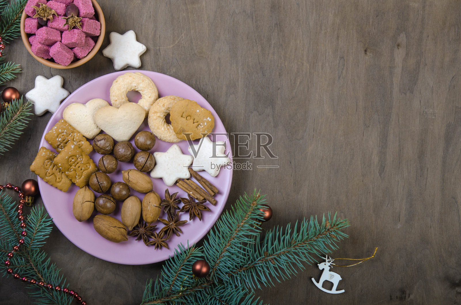 茶托里放饼干,木碗里放糖,还有云杉树枝。照片摄影图片