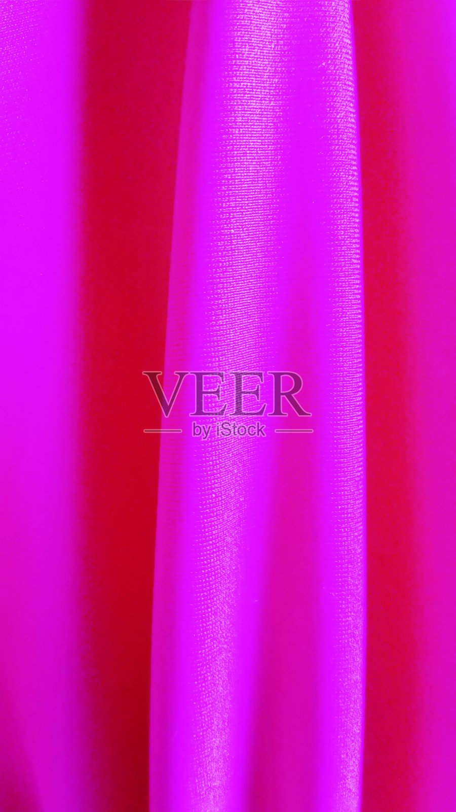 有弹性的亮粉色面料,带有一种凉爽的色调。用于缝制泳装、运动服、内衣裤。在弹力织物上,织造结构和单线迹是很明显的照片摄影图片