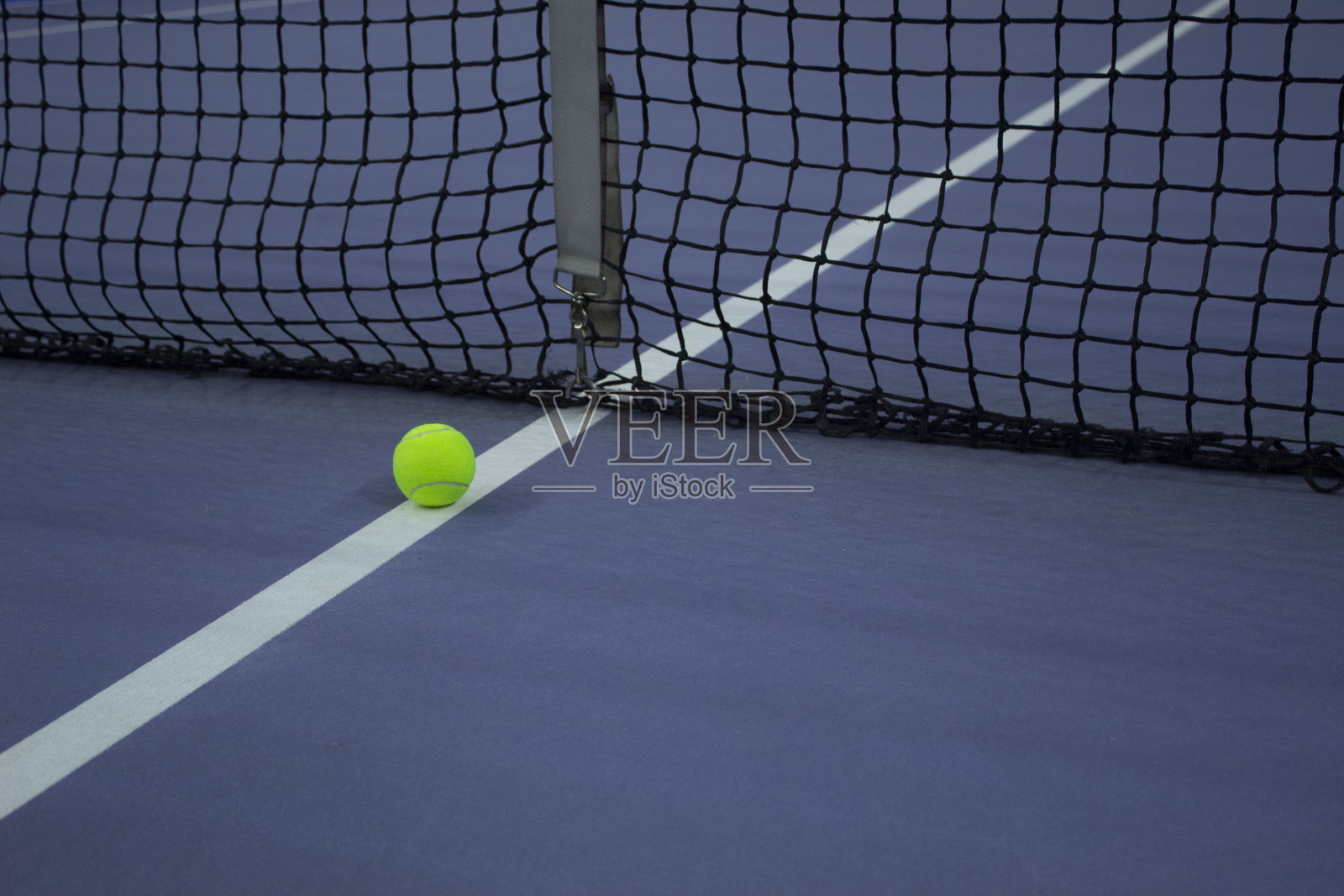 在蓝色网球场的网球线上放置的网球照片摄影图片