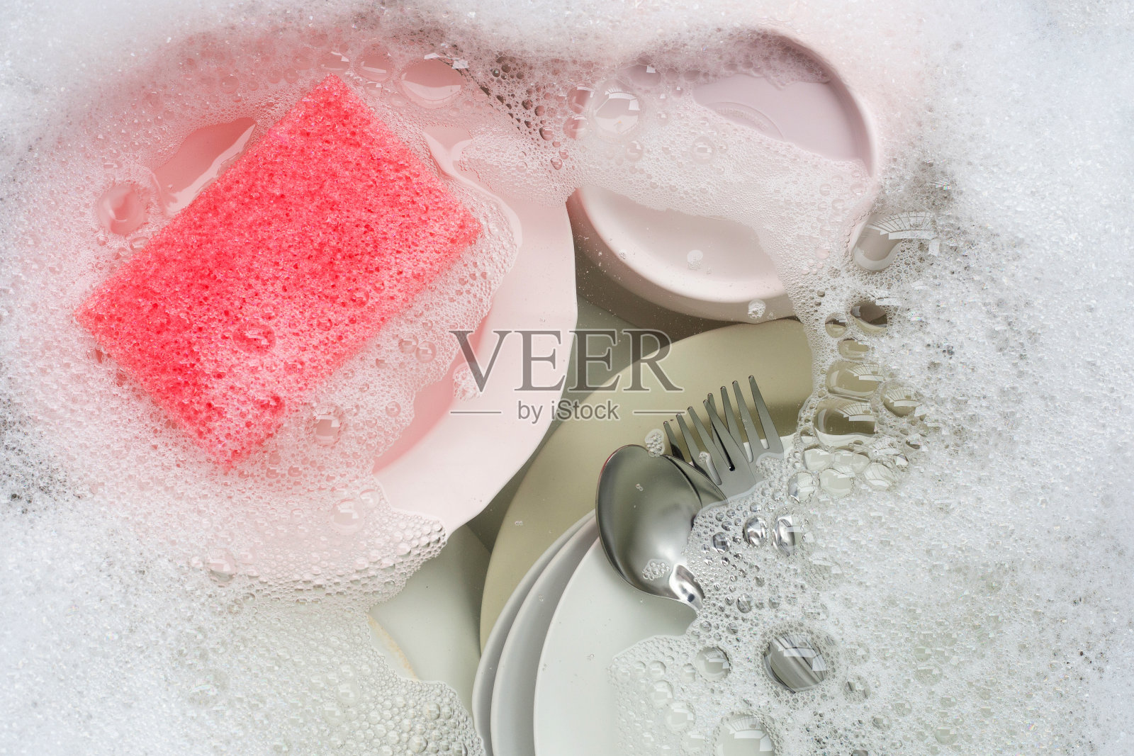 洗盘子,靠近浸泡在厨房水槽中的器具。照片摄影图片