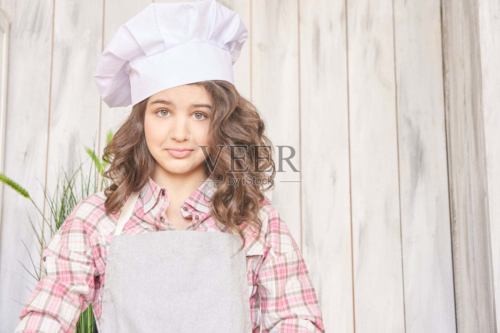 美丽的女孩。小厨师。白色帽子,棕色卷发照片摄影图片