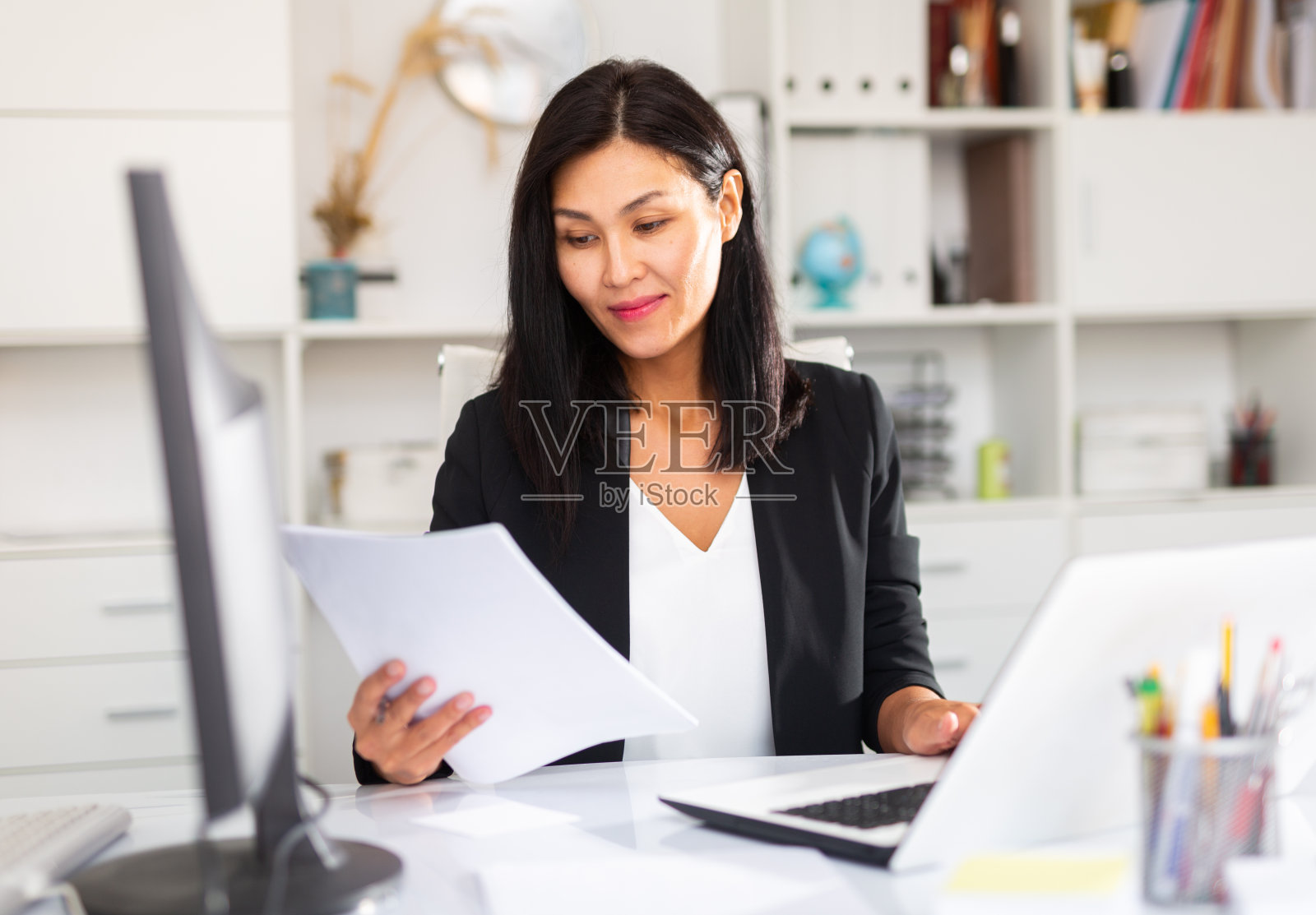 微笑的女人处理文件和笔记本电脑照片摄影图片