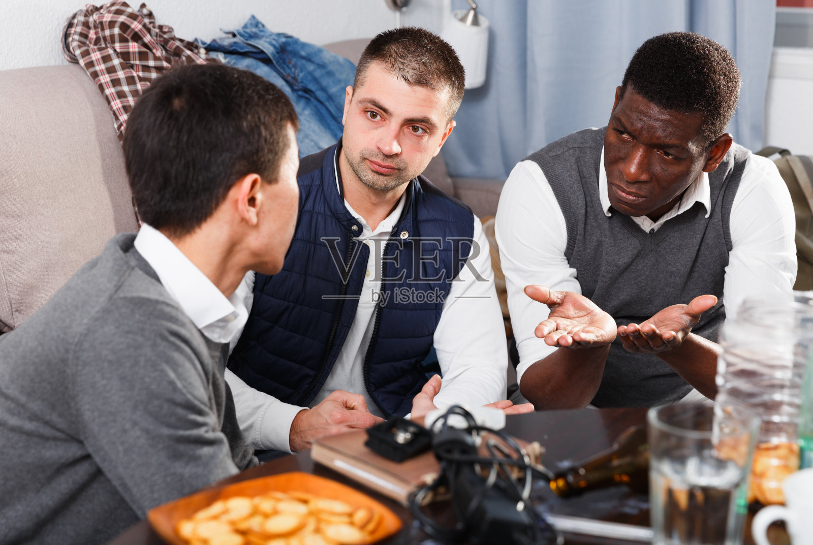 三个男人一边喝着啤酒一边争论着照片摄影图片