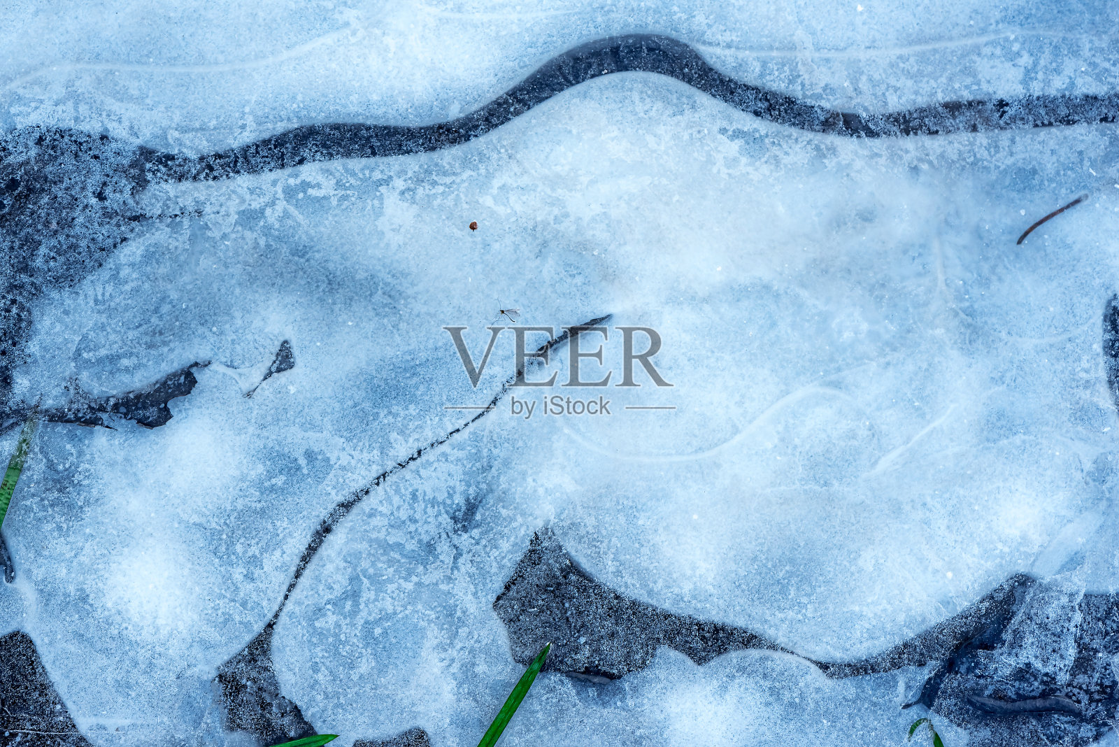 冬季覆盖在水面上的天然冰。冰的质地与霜的点缀,冰冻水的晶体。照片摄影图片