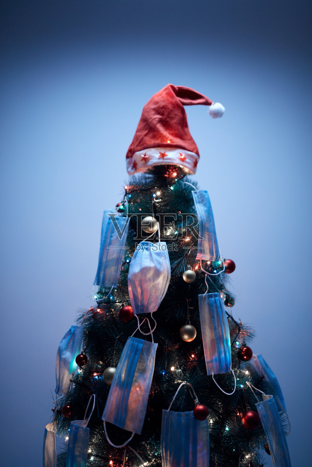 装饰着医用口罩的圣诞树——2020 / 2021年病毒大流行的插图社交距离、封锁和隔离。照片摄影图片