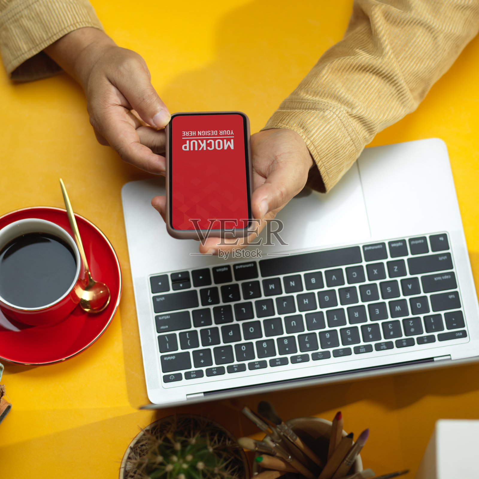 男性用手将智能手机与笔记本电脑和咖啡杯放在桌子上,剪下路径照片摄影图片