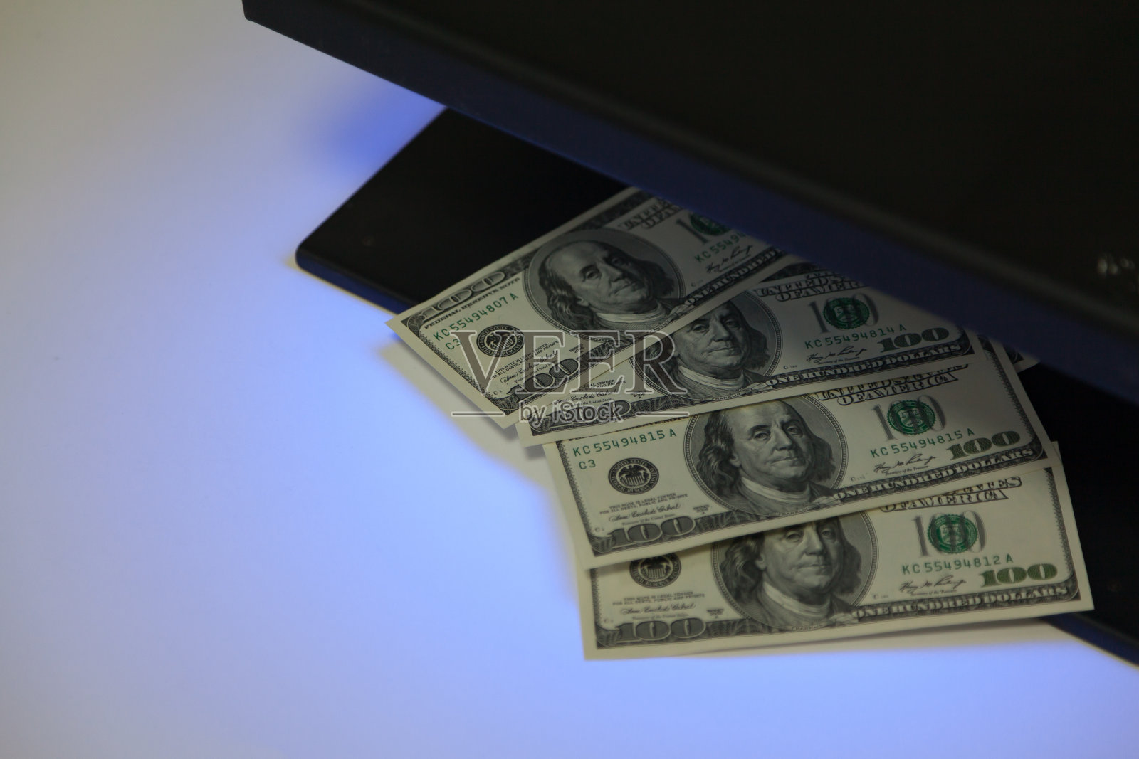 钞票藏在黑色金属探测器里照片摄影图片