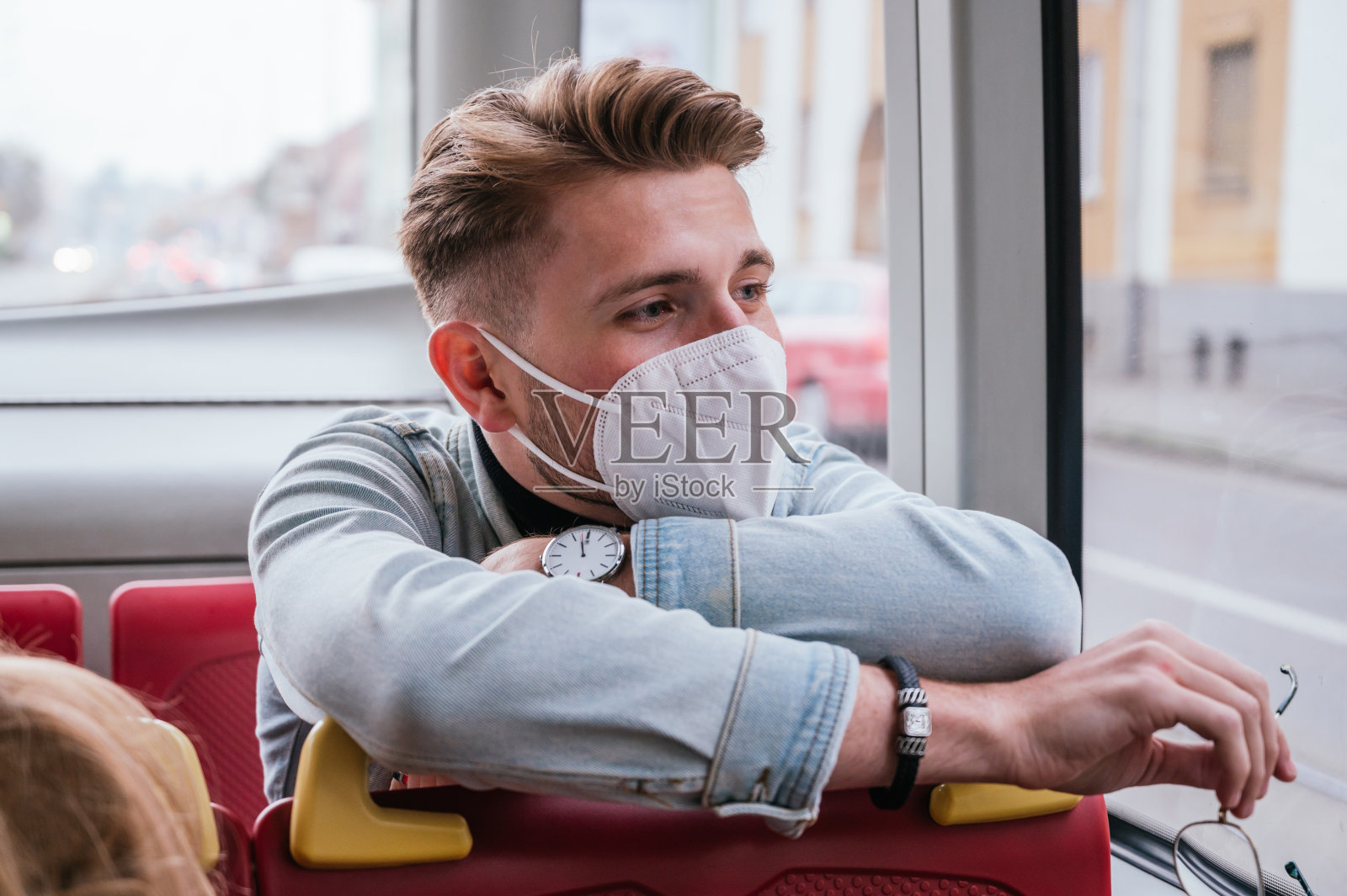 年轻人戴着面具坐在公共交通工具上照片摄影图片