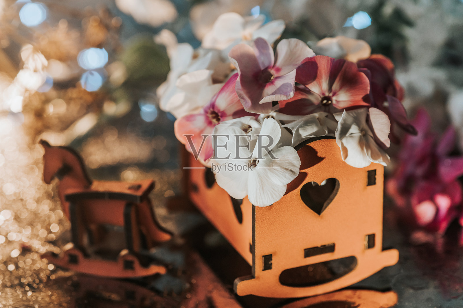 木制家具。玩具屋家具和花。儿童木制家具和花园里的花。木制玩具被精致的花朵包围着照片摄影图片