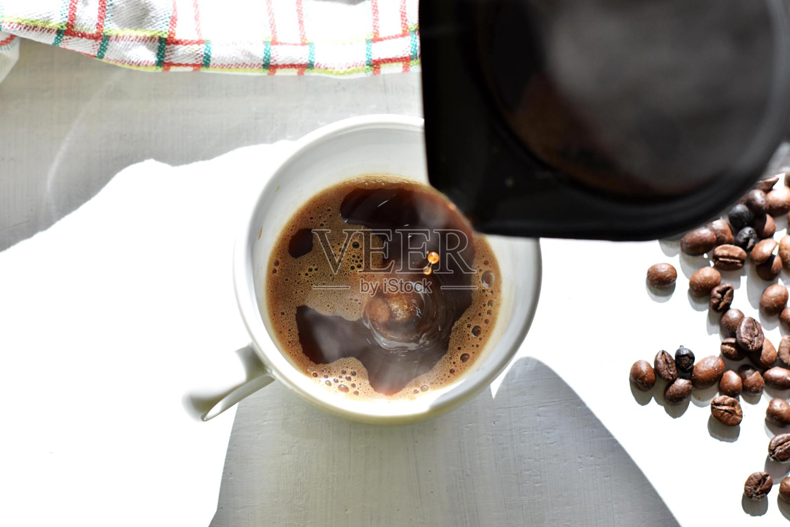 早上起床后,将新鲜的热黑咖啡倒入杯中/热黑土耳其咖啡提供早餐照片摄影图片