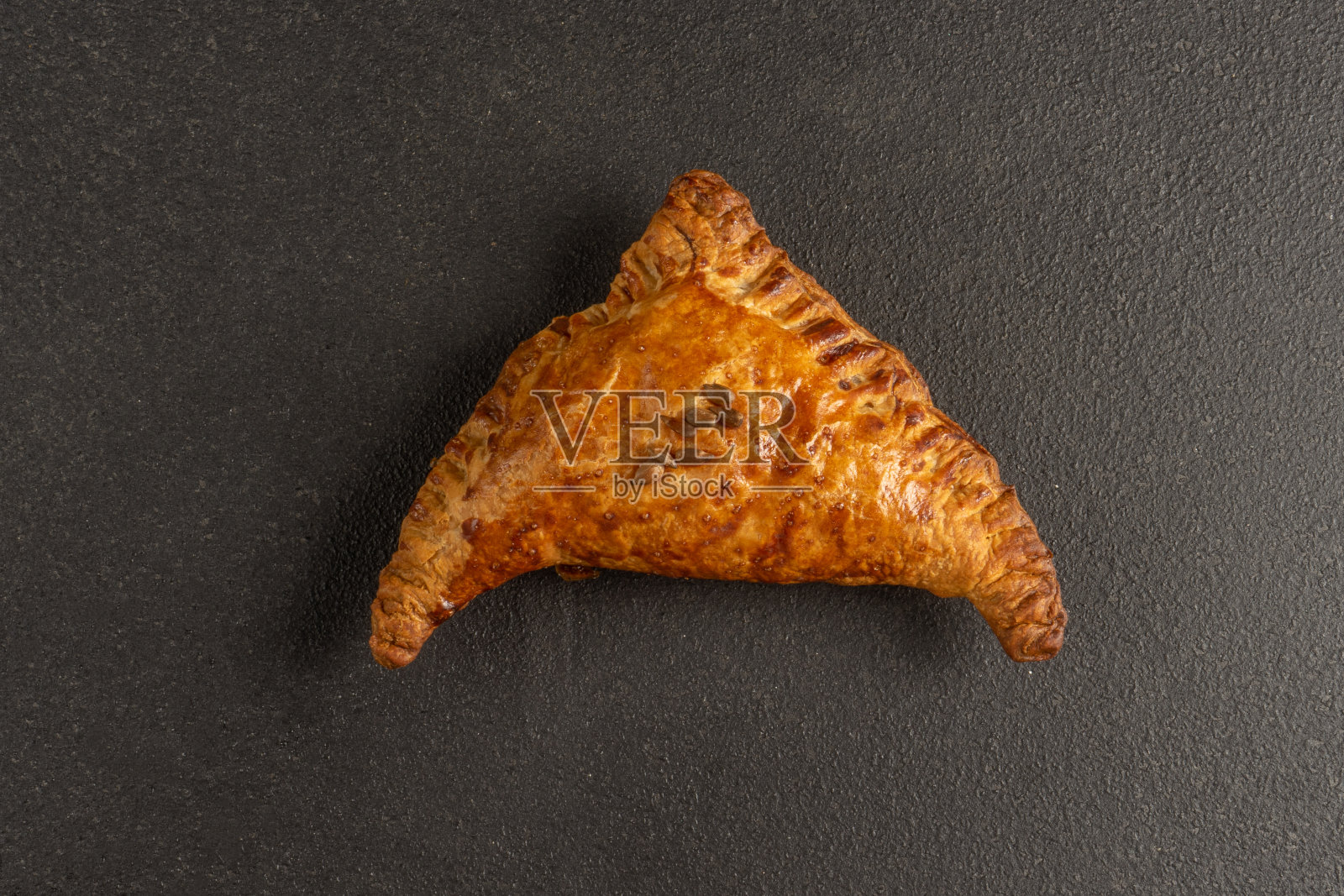 新鲜的小麦包馅。黄油甜面粉烘焙产品在黑色的背景。照片摄影图片