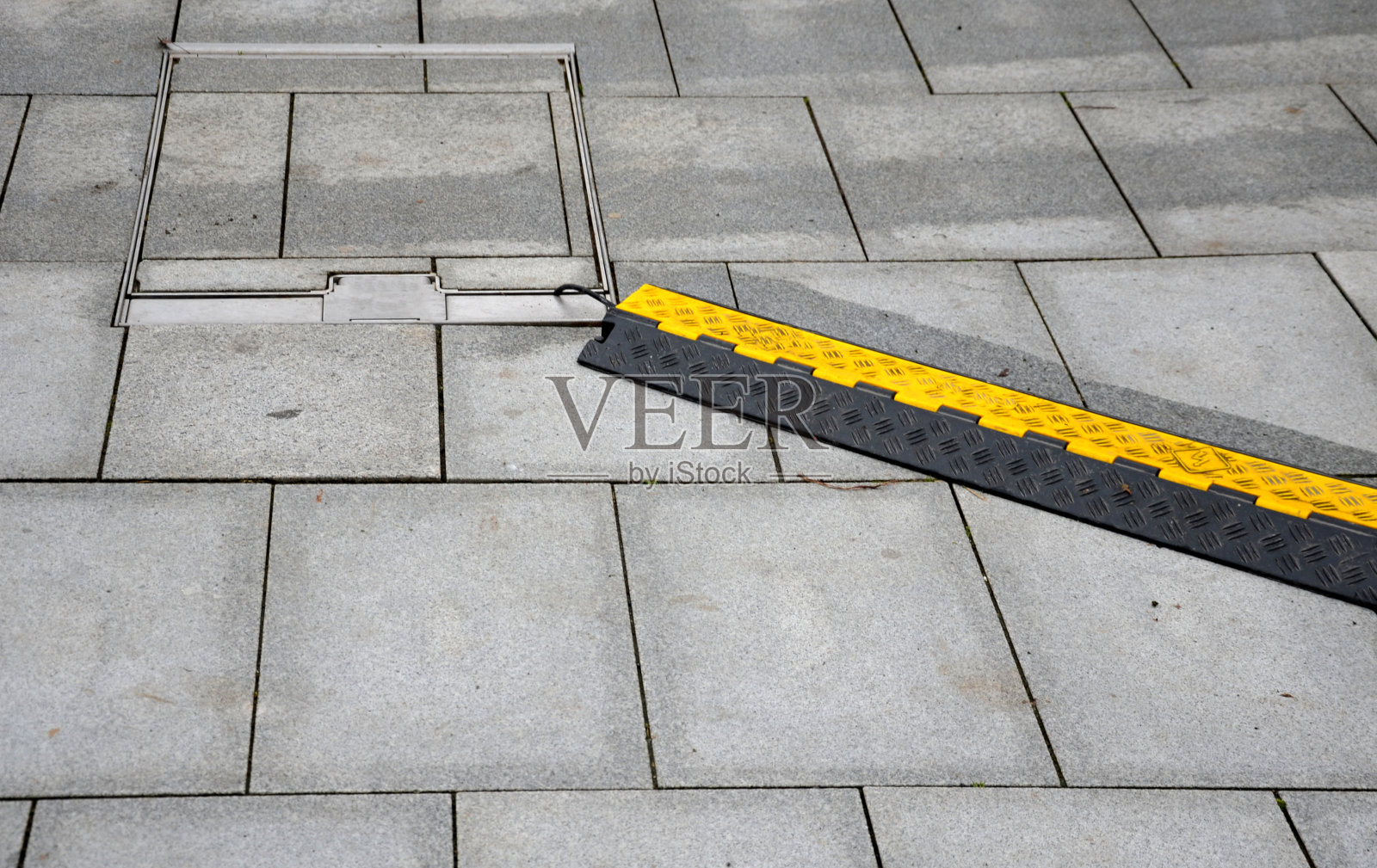 通过步行铺设的人行道连接电缆。保护电缆或软管的安全方法。汽车、自行车和行人可以通过从总机可见的黄色障碍物。防护式电缆桥架专为五种电缆设计。阅读全文照片摄影图片