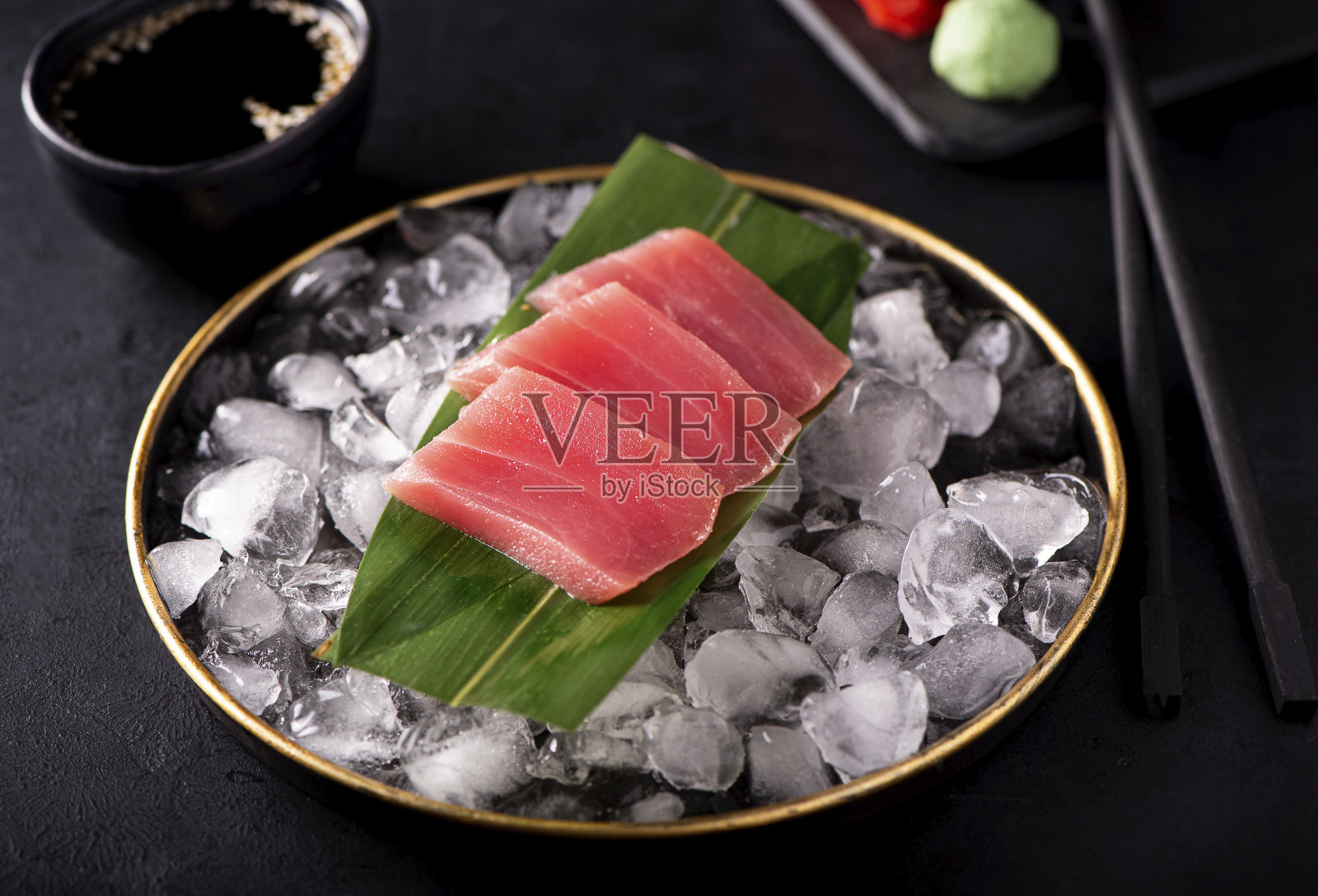 黑色盘子里的金枪鱼生鱼片照片摄影图片