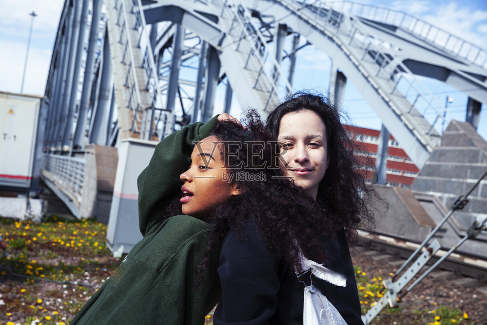 年轻可爱的少女一起在工业园区快乐地笑着玩,大城市的生活方式时尚的人照片摄影图片