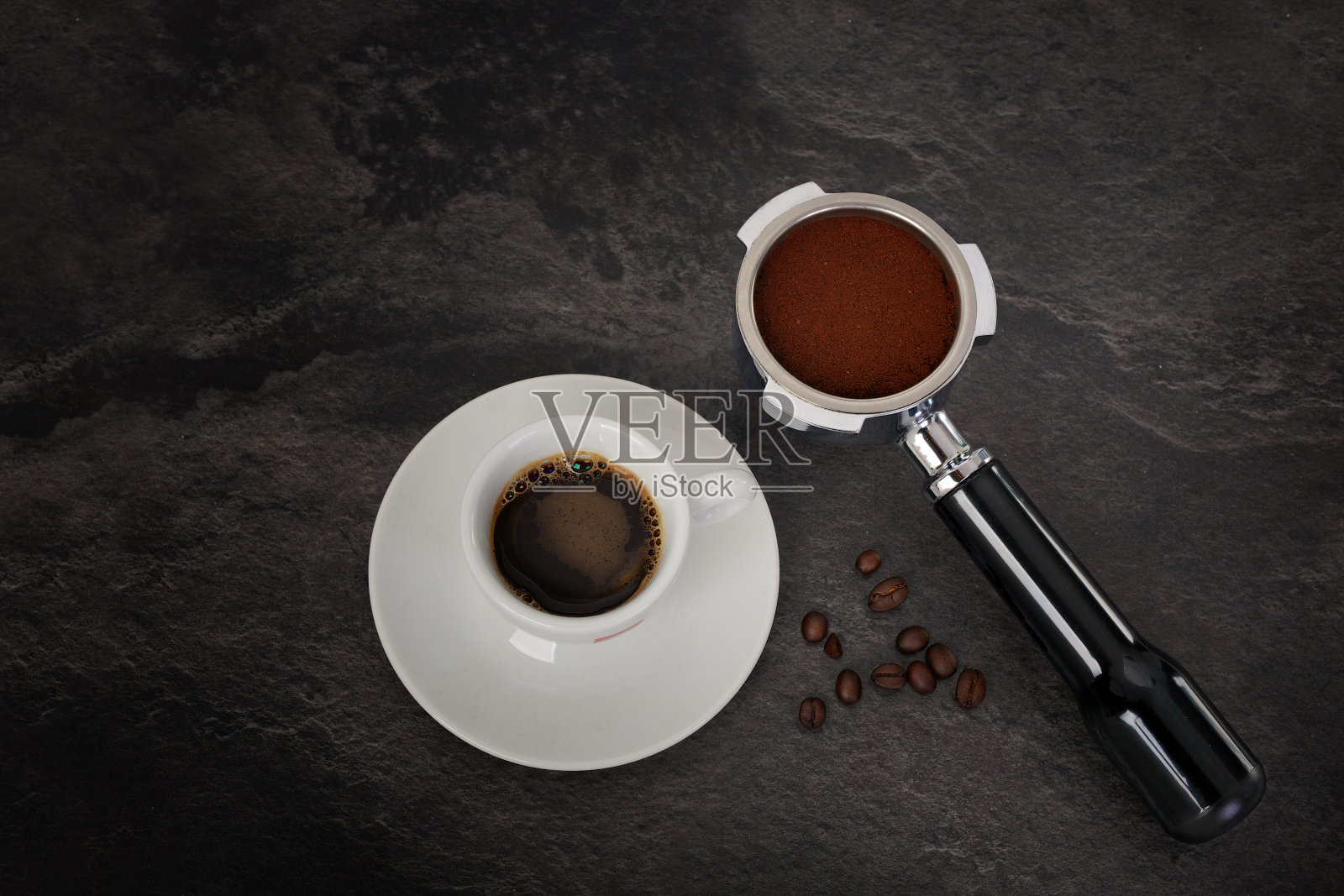 黑色背景上的咖啡机过滤网和浓缩咖啡杯。照片摄影图片