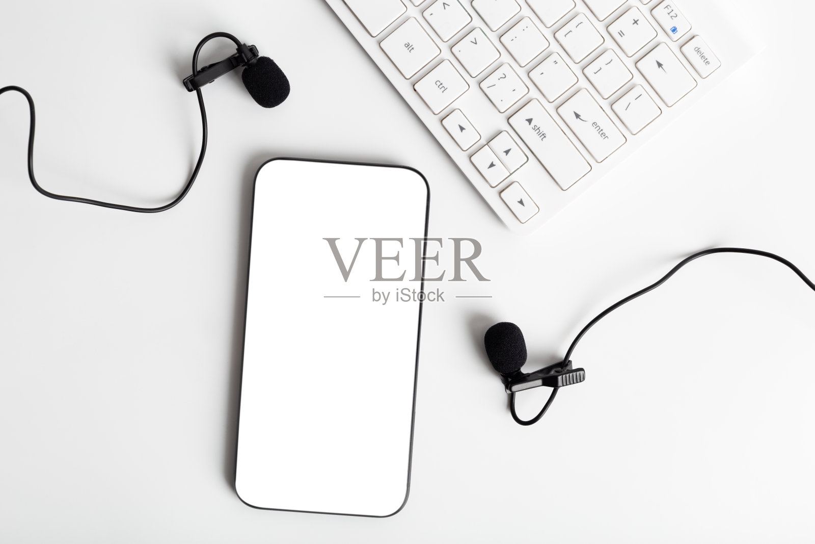 播客概念。智能手机和黑色麦克风在桌面上。照片摄影图片