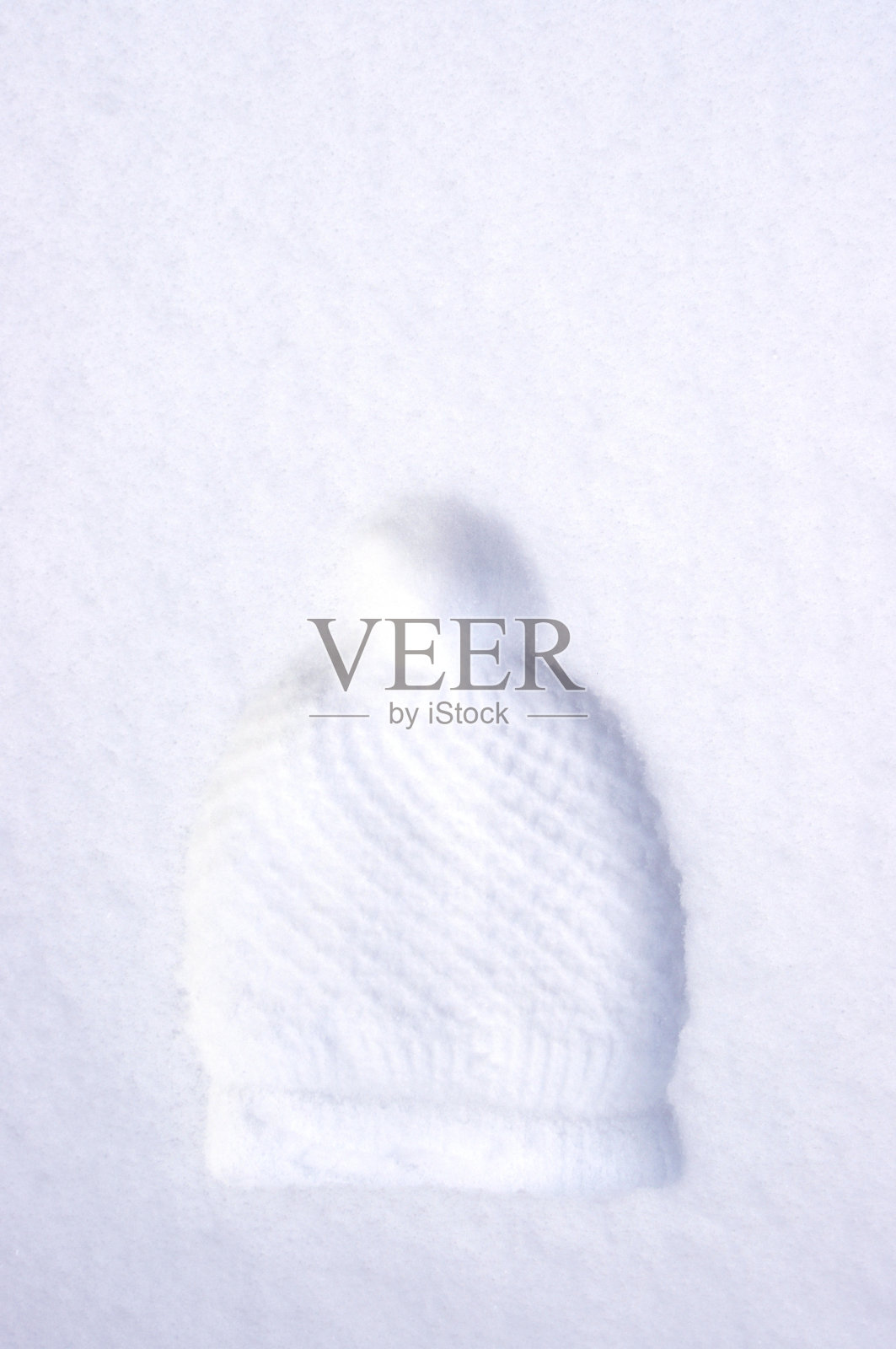 冬季帽子与绒球印在白色的雪照片摄影图片