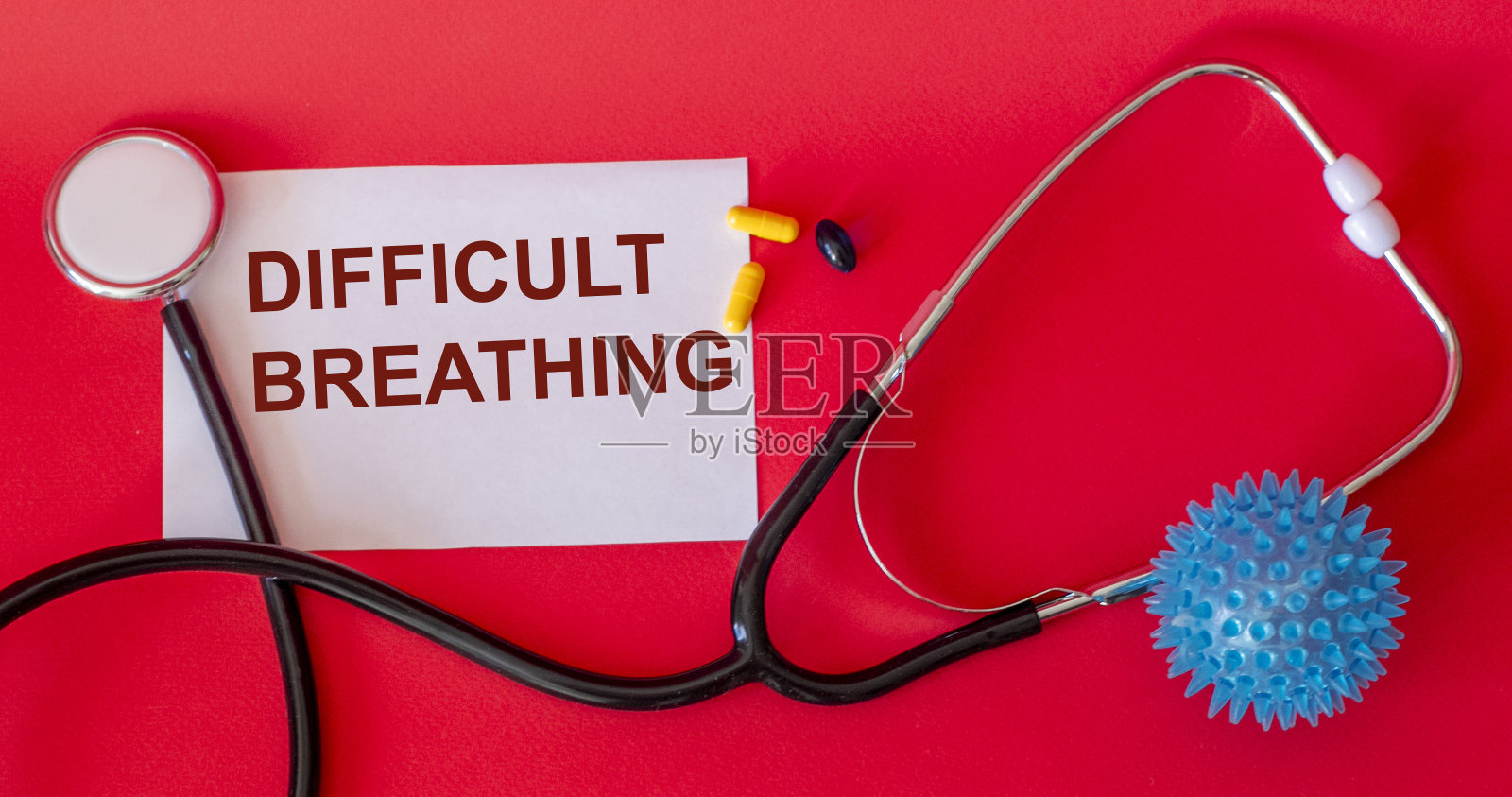 呼吸困难——这个词写在白纸上,背景是红色的,旁边是听诊器。呼吸道疾病症状照片摄影图片