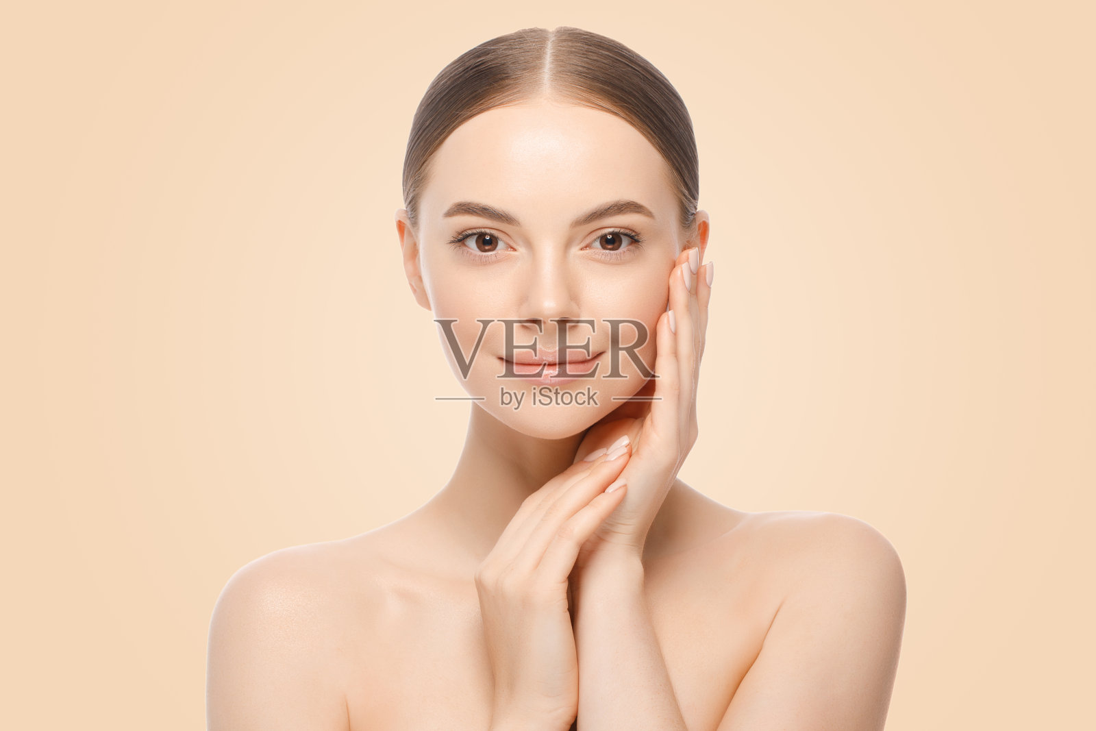 美丽的女人或女性模特的肖像牵手近面部与完美的清洁皮肤,孤立在棕色的背景照片摄影图片