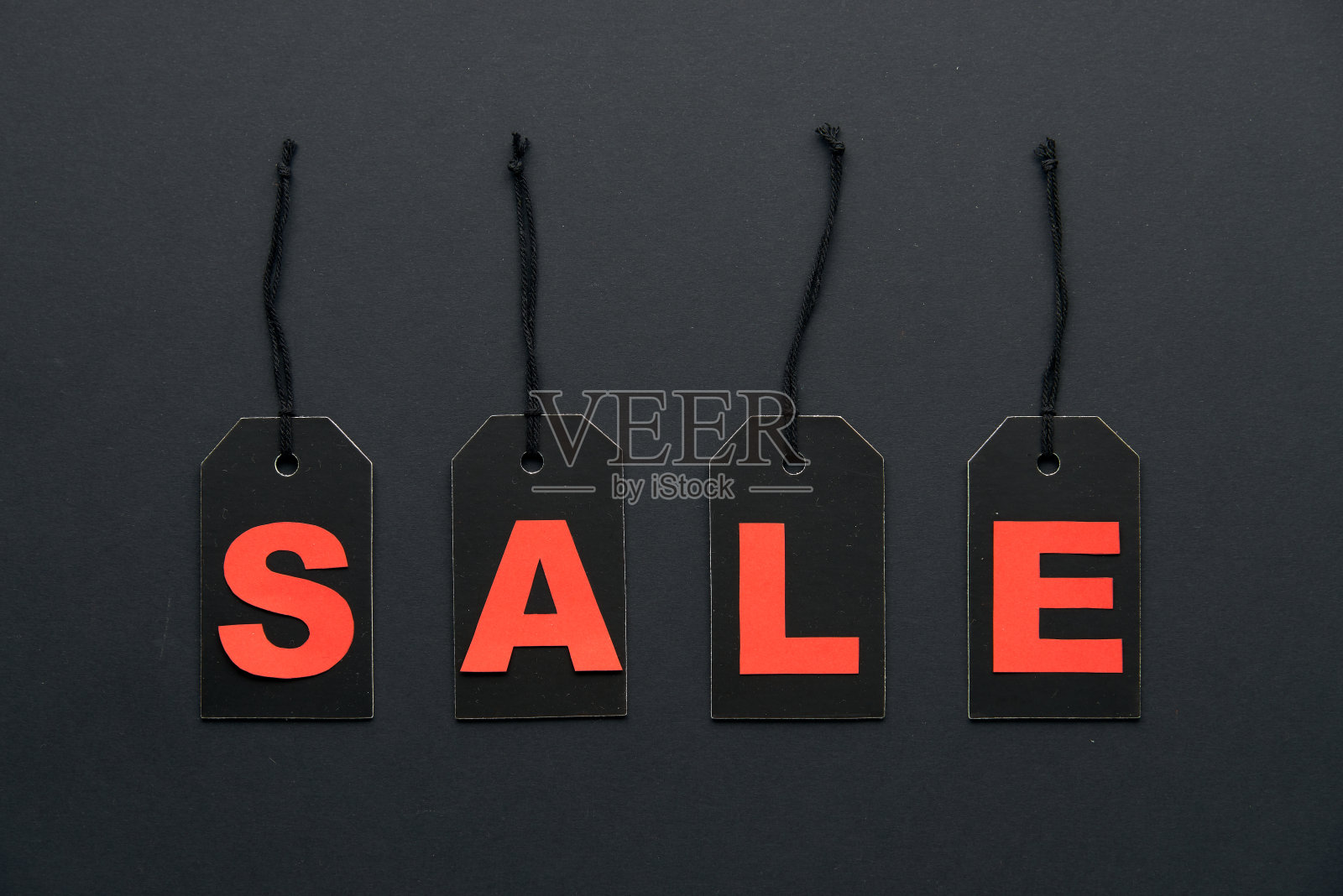 文字销售写在黑色的硬纸板标签或价格标签,与电线隔离在黑暗的背景。BlackÂ周五,购物,销售和营销的概念。俯视图,平放,复制空间。照片摄影图片