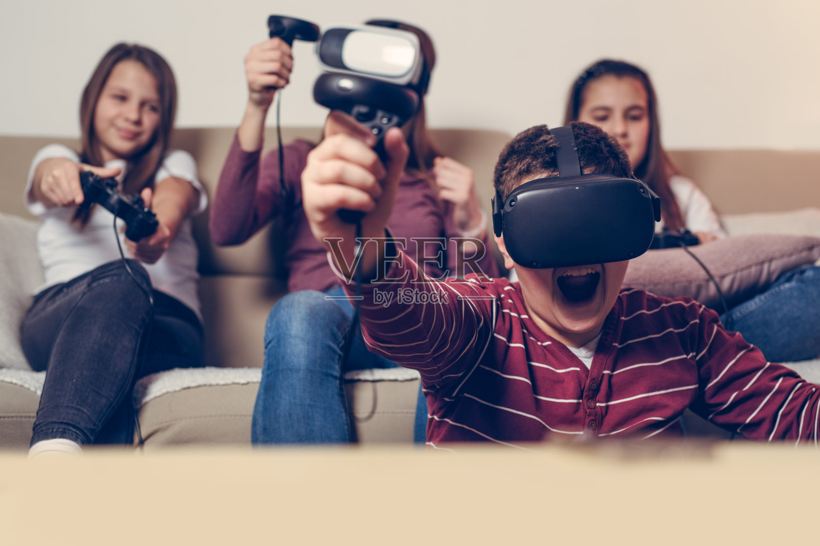 青少年在家里玩电子游戏。照片摄影图片