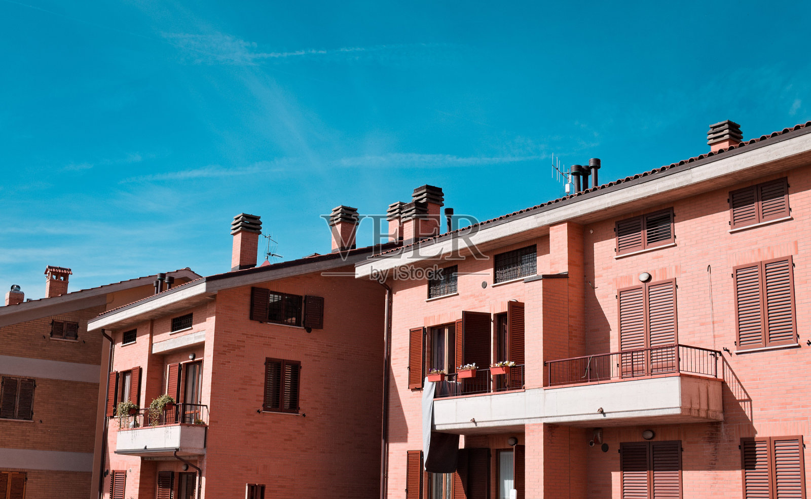 屋顶上有烟囱的一系列公寓的正面视图(古比奥,意大利,欧洲)照片摄影图片