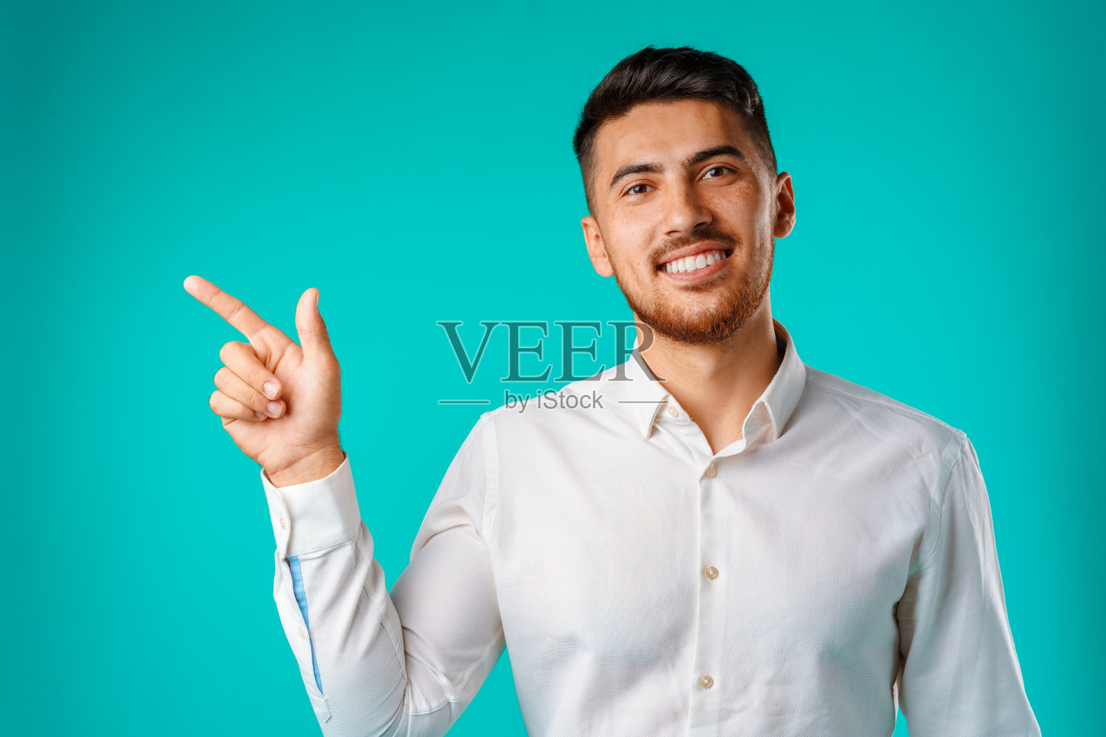 年轻英俊的男子站在一边,指着手指照片摄影图片