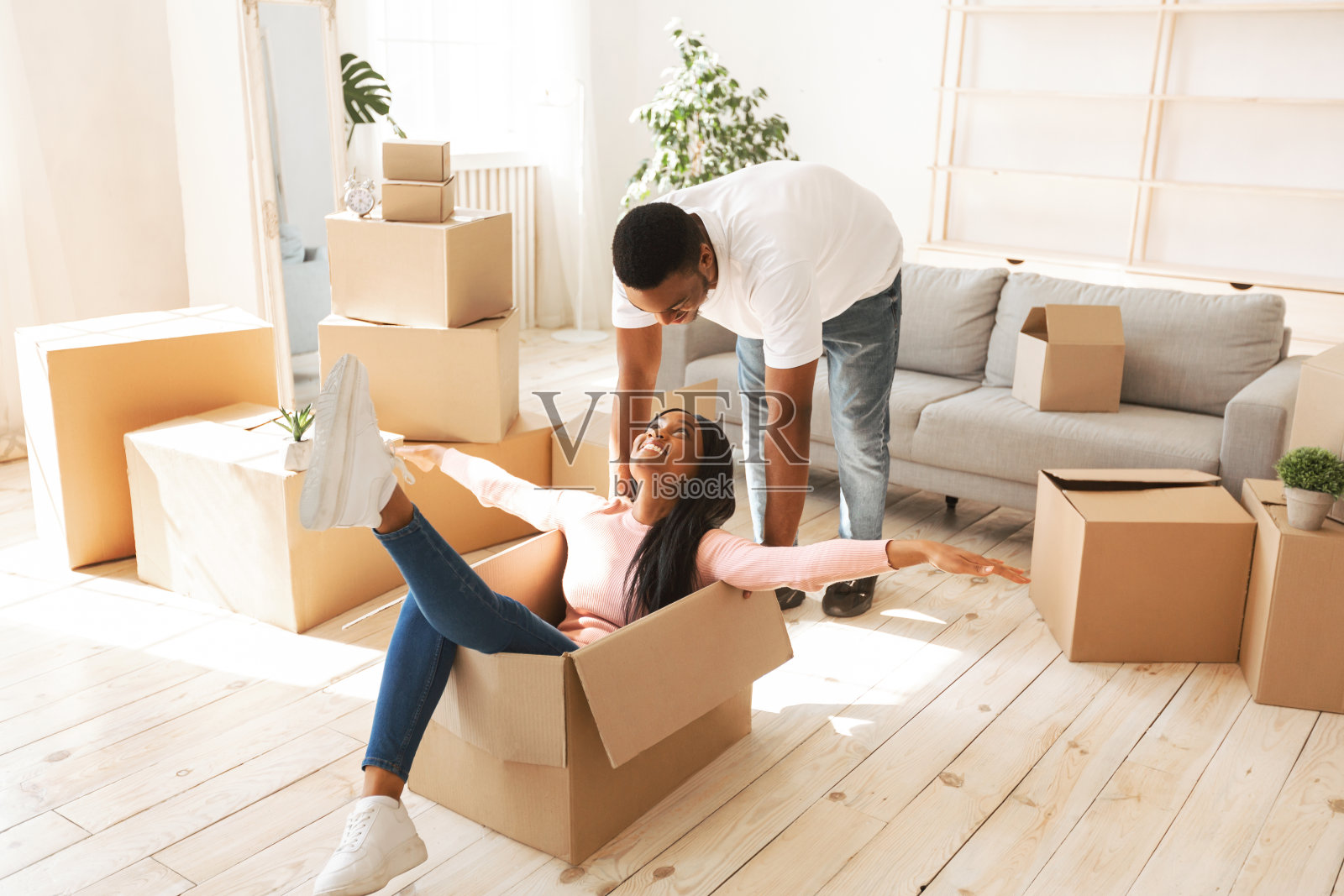 好玩的黑人夫妇有乐趣在他们的新公寓搬迁日照片摄影图片