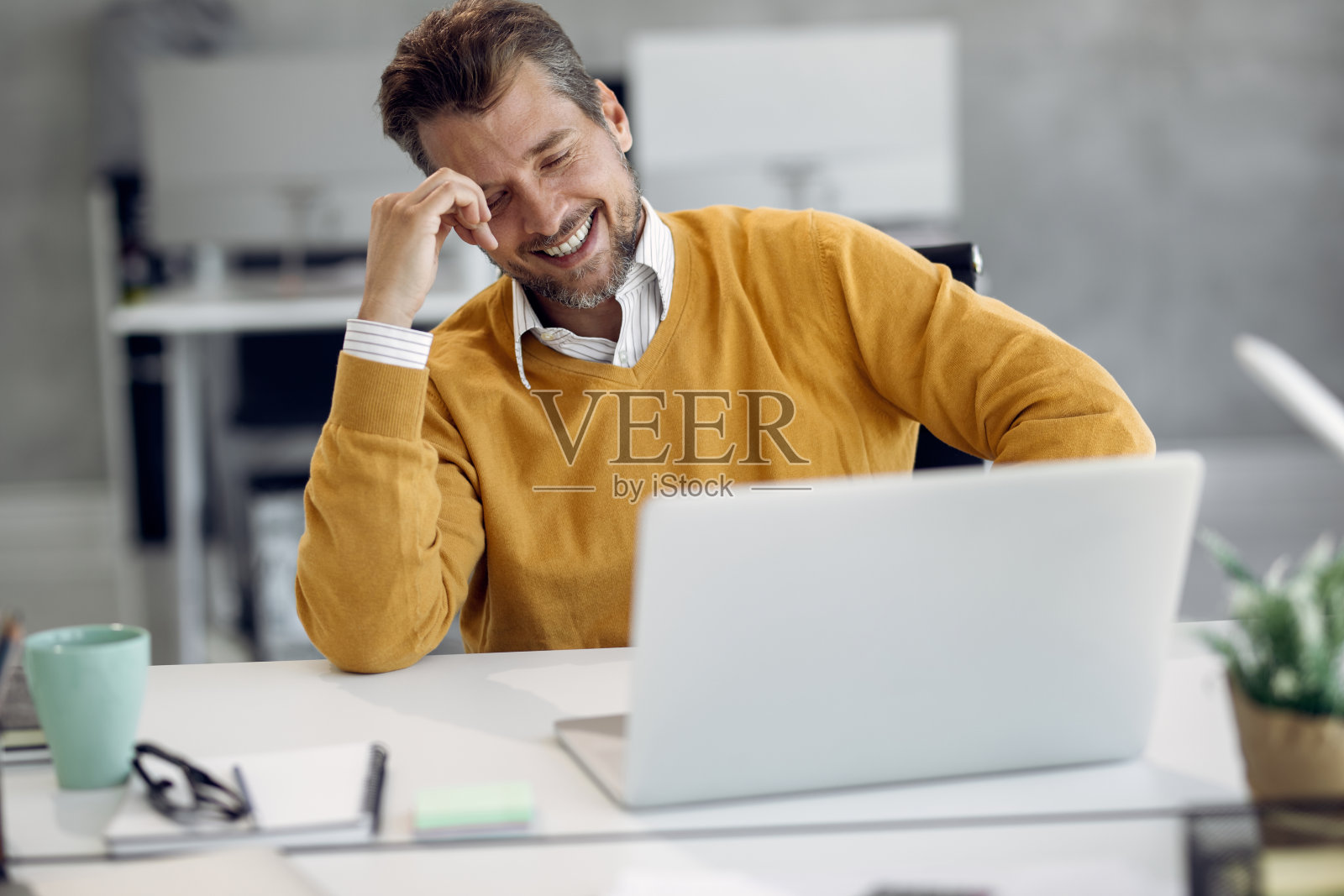 愉快的商人在办公室视频通话期间的乐趣。照片摄影图片