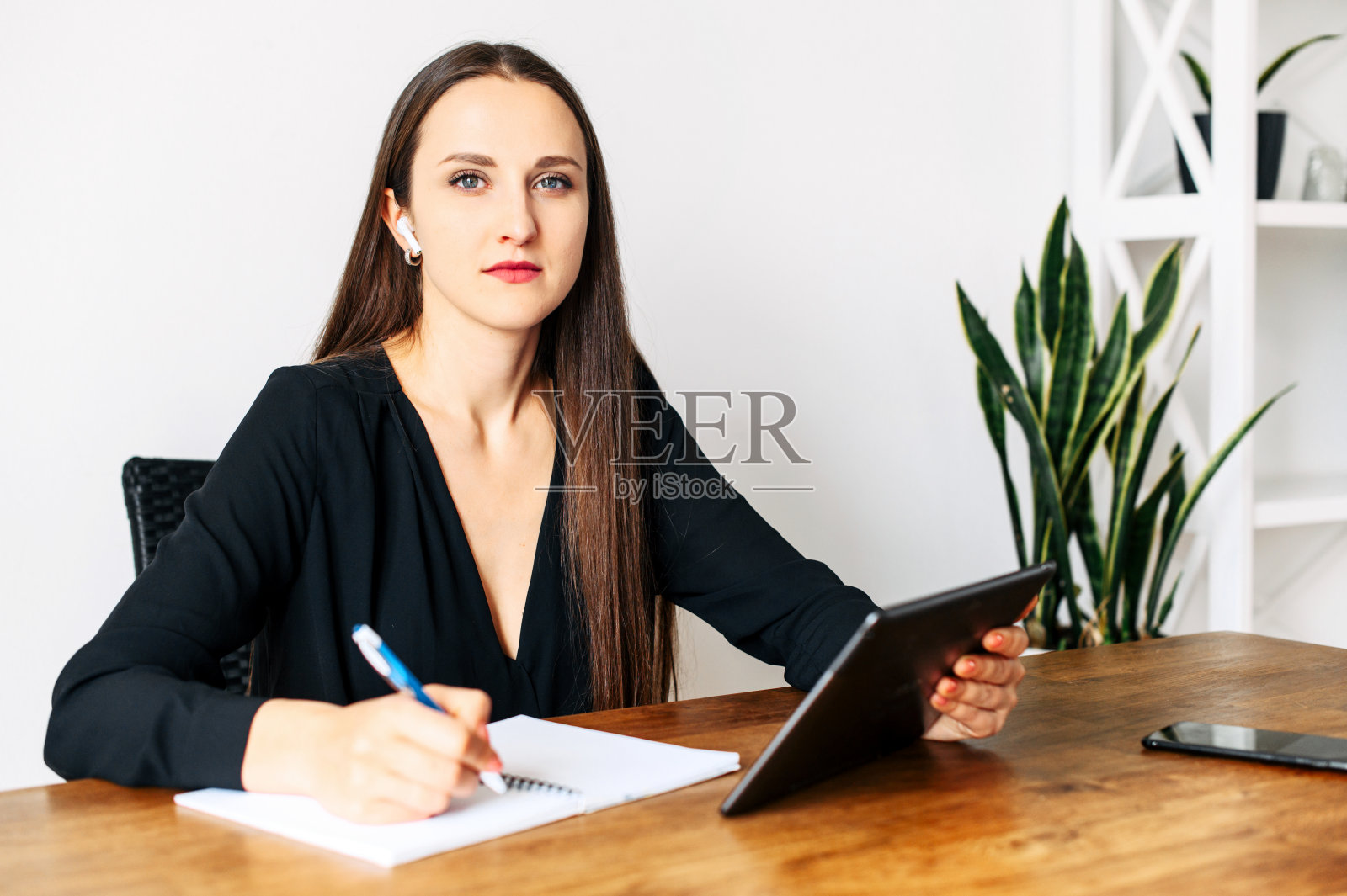 穿着黑衬衫拿着平板电脑的女人照片摄影图片