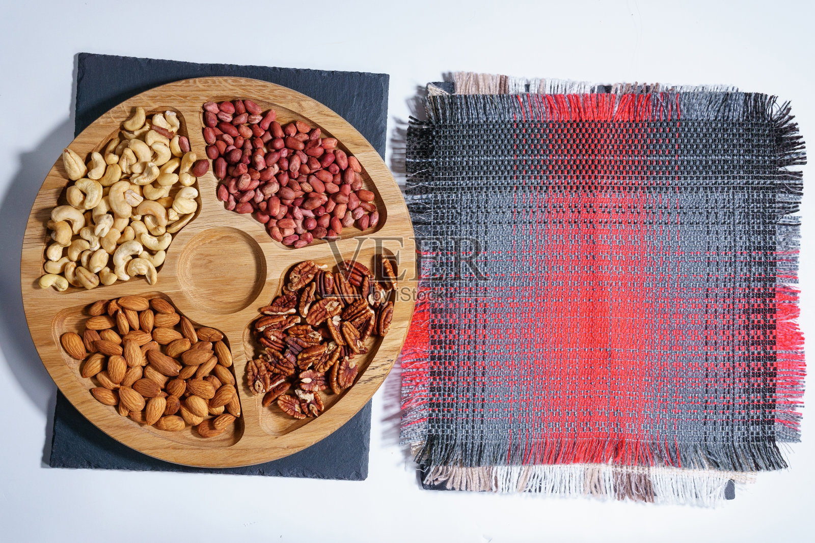 石头桌上放着各种坚果。顶部视图与空间复制。腰果,山核桃,花生,杏仁照片摄影图片