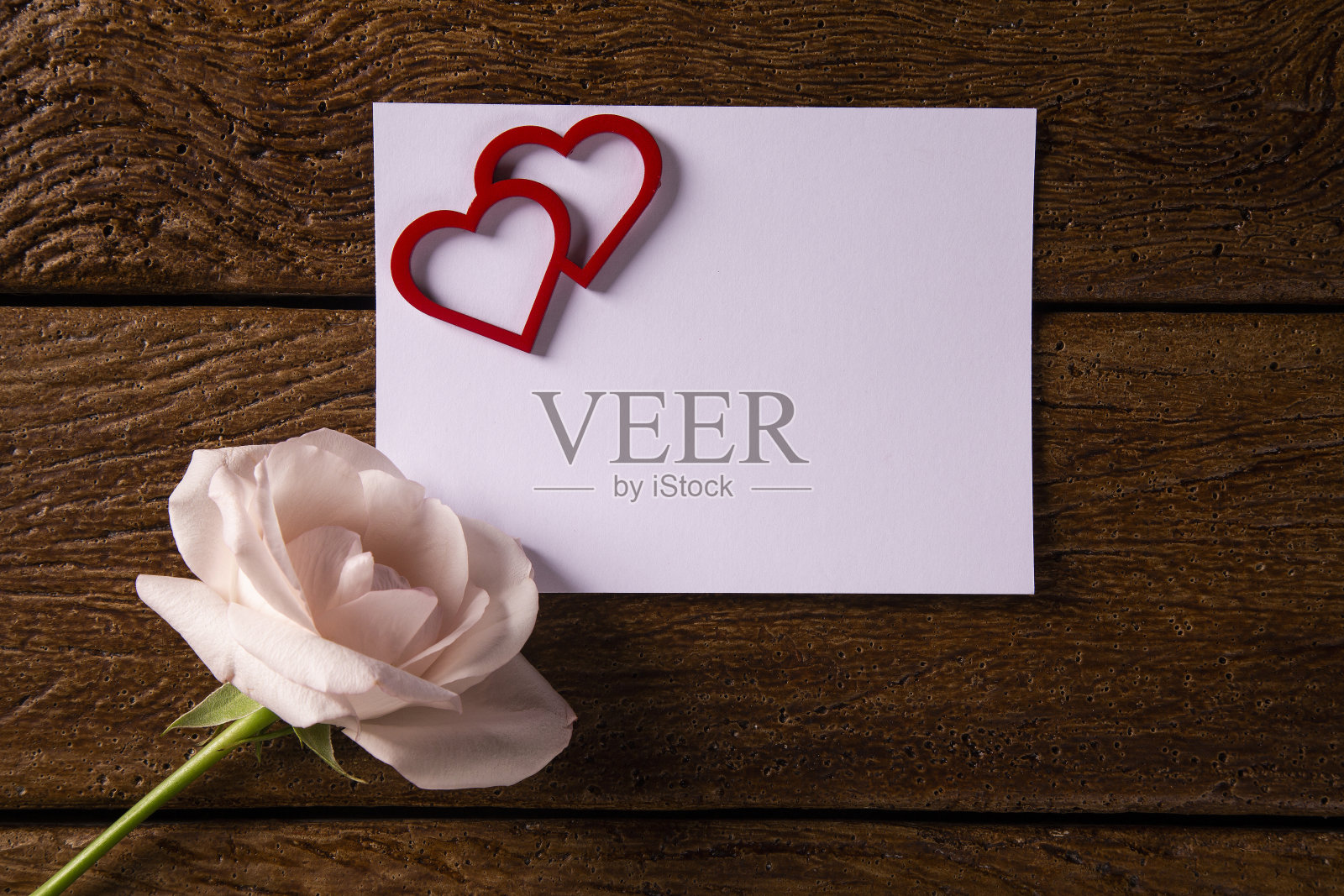 木桌上放着红玫瑰和情人节贺卡。顶部视图与复制空间照片摄影图片