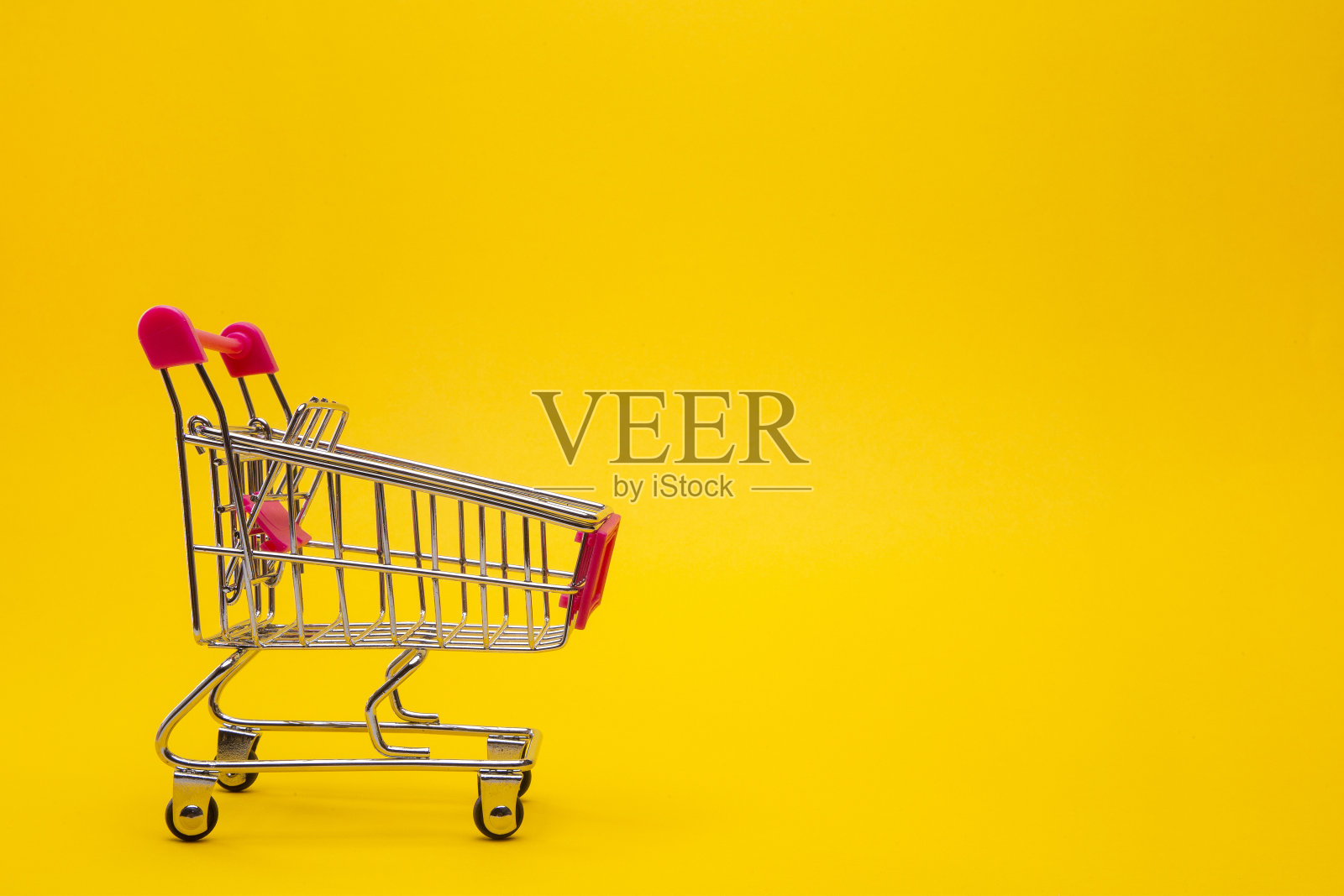 在黄色背景上清空购物车。照片摄影图片